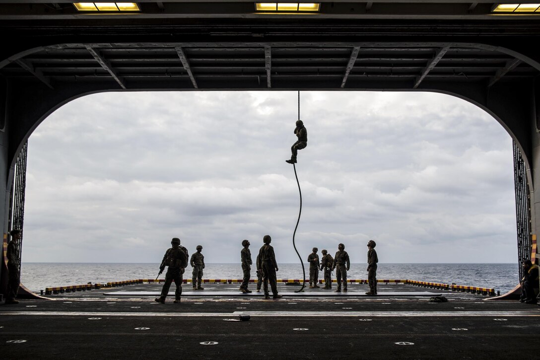 Marines fast-rope from an MV-22B Osprey onto the port aircraft elevator of the amphibious assault ship USS Bonhomme Richard in the Philippine Sea, March 21, 2017. The ship is operating in the Indo-Asia-Pacific region to enhance warfighting readiness for any type of contingency. Navy photo by Seaman Apprentice Jesse Marquez Magallanes