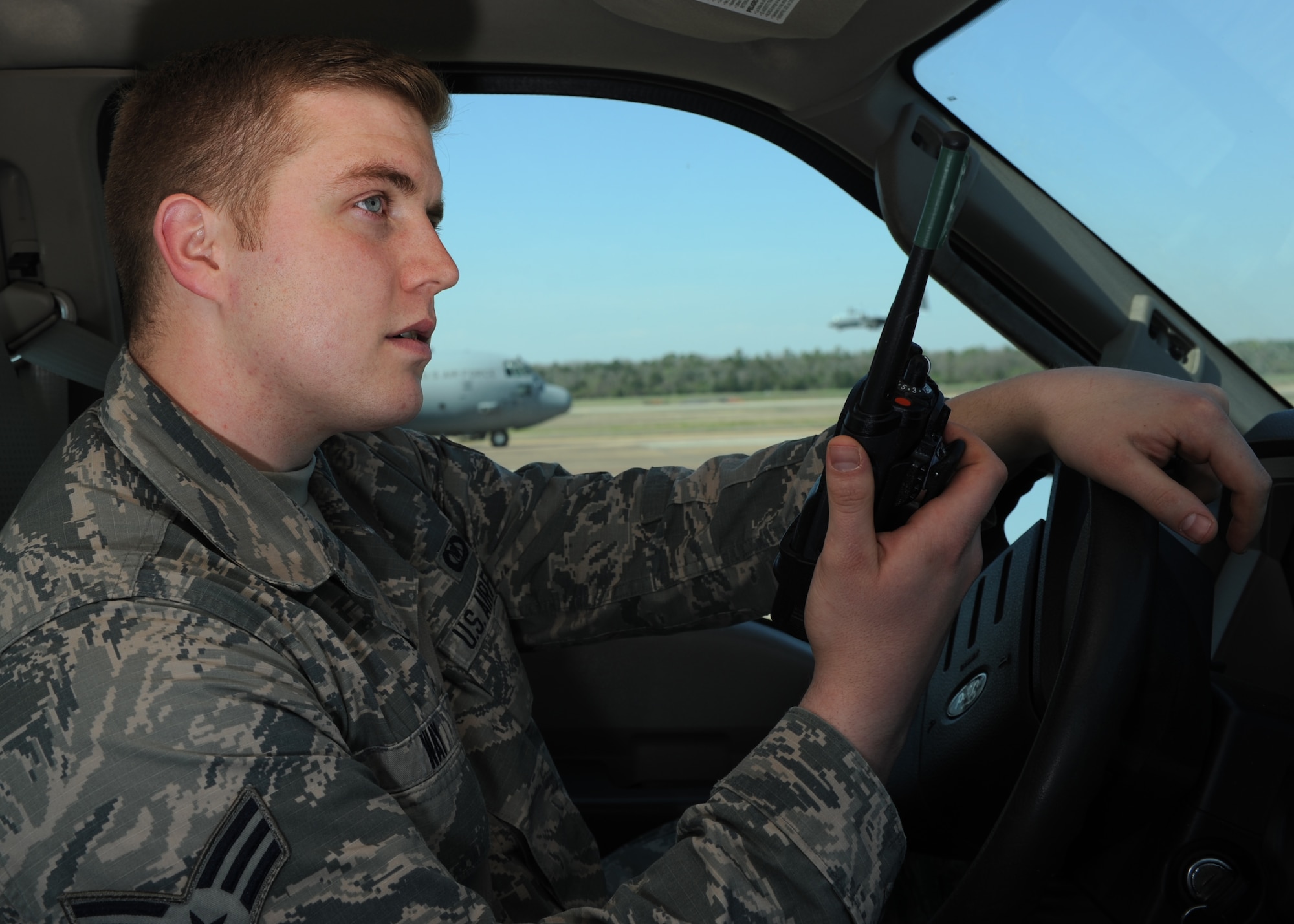 U.S. Air Force Senior Airman Joseph Way, 19th Operations Support Squadron Airfield Management shift lead, listens for radio instructions March 20, 2017, at the flightline on Little Rock Air Force Base, Ark. Eleven service members and two civilians make up the airfield management crew, responsible for ensuring a safe and ready airfield. (U.S. Air Force photo by Airman 1st Class Grace Nichols)