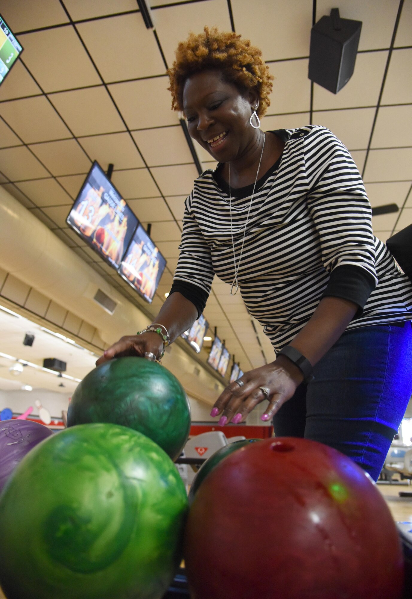 Keesler personnel celebrate a strike during a Care for the Caregiver event at Gaudé Lanes March 23, 2017, on Keesler Air Force Base, Miss. The event, hosted by the 81st Training Wing Chapel staff, was open to units who provide mental, spiritual and social care for Airmen and their families and included fellowship, bowling and food. (U.S. Air Force photo by Kemberly Groue)
