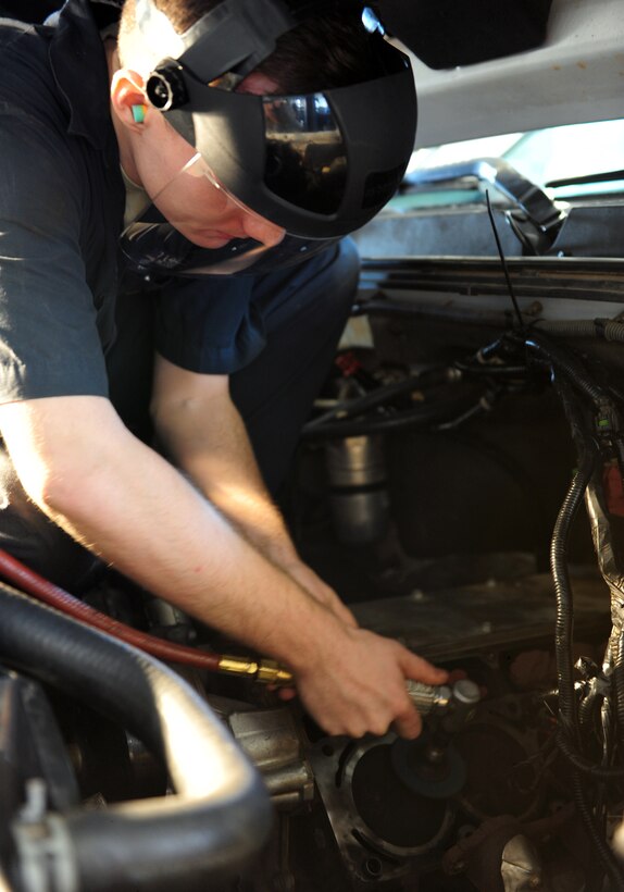 U.S. Air Force Airman 1st Class Jack McKeown, 7th Logistics Readiness Squadron vehicle mechanic, buffs an engine block at Dyess Air Force Base, Texas, March 21, 2017. Old gaskets are buffed off the engine block in order to create a clean and tight seal between the cylinder head and engine block with a new gasket. (U.S. Air Force photo by Airman 1st Class April Lancto)