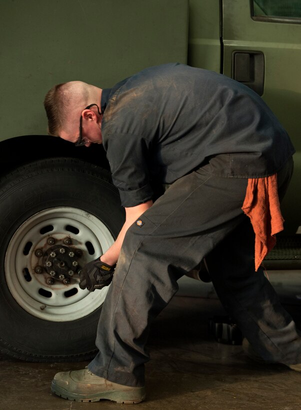 U.S. Air Force Senior Airman Bradley Hall, 7th Logistics Readiness Squadron vehicle mechanic, unscrews a bolt before replacing a tire at Dyess Air Force Base, Texas, Jan. 5, 2017. Vehicle maintenance repairs range from tire replacement to engine starter repairs. (U.S. Air Force photo by Airman 1st Class April Lancto)