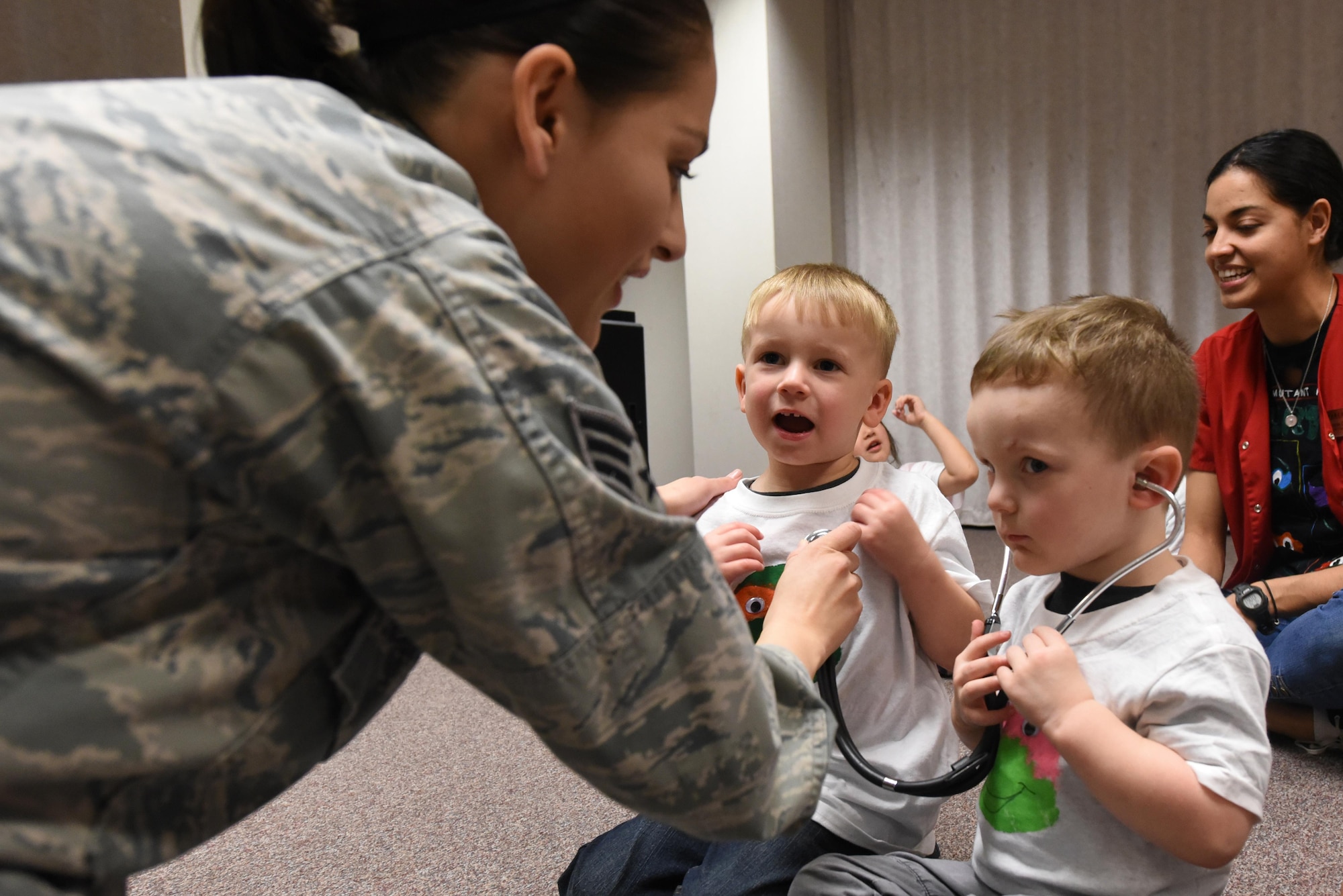 Senior Airman Elenacorozal  Denny, 4th Medical Operations Squadron medical technician, teaches children from the 4th Force Support Squadron Child Development Center how to use a stethoscope, March 21, 2017, at Seymour Johnson Air Force Base, North Carolina. The children listened to each other’s heartbeats, read books about the body and toured the pediatric clinic. (U.S. Air Force photo by Airman 1st Class Victoria Boyton)