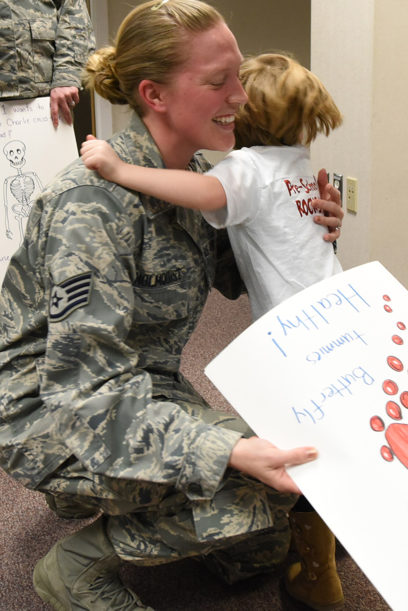Staff Sgt. Erin Holmquist, 4th Medical Operations Squadron medical laboratory technician, hugs a preschooler from the 4th Force Support Squadron Child Development Center, March 21, 2017, at Seymour Johnson Air Force Base, North Carolina. The children presented the laboratory staff with a thank you card during a field trip visit. (U.S. Air Force photo by Airman 1st Class Victoria Boyton)