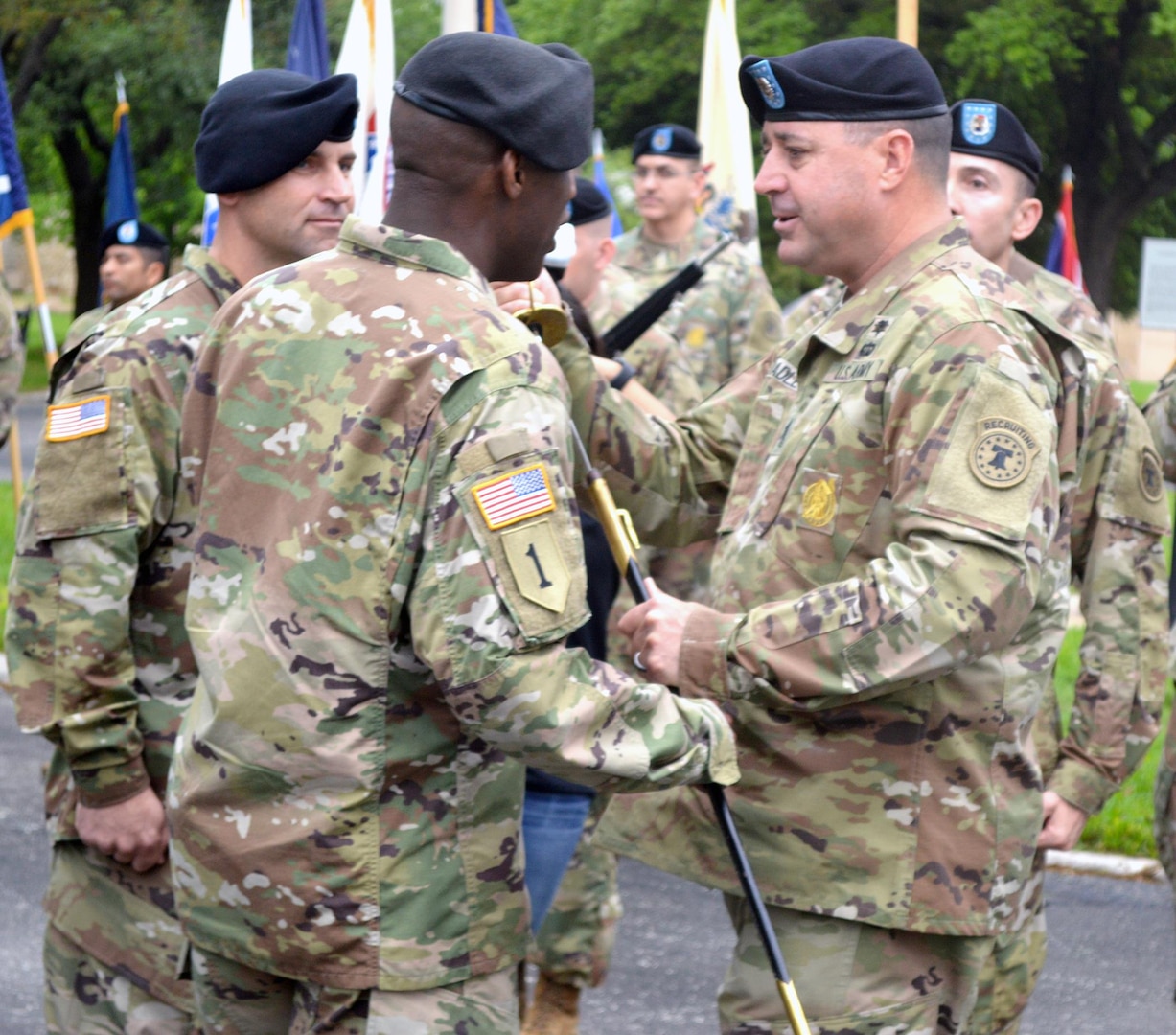 Command Sgt. Maj. Stephen Badley (right), outgoing command sergeant major for the U.S. Army’s 5th Recruiting Brigade at Joint Base San Antonio-Fort Sam Houston, relinquishes the NCO sword to Col. Terance Huston (center), brigade commander, during the brigade’s change of responsibility ceremony March 24 at the historic quadrangle on JBSA-Fort Sam Houston.