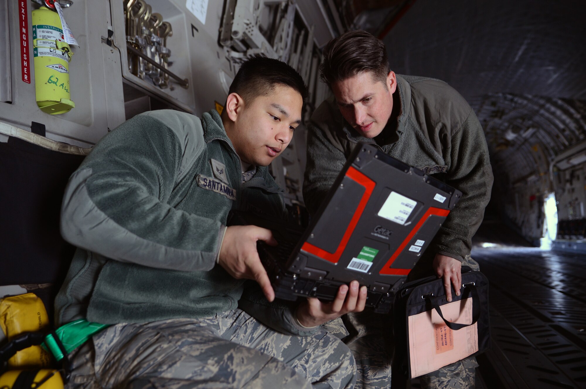Senior Airman Facundo Santamina (left), 62nd Aircraft Maintenance Squadron crew chief and Staff Sgt. James Pomeroy, 62nd AMXS crew chief, review a technical order prior to performing maintenance on a C-17 Globemaster III aircraft March 20, 2017 at Joint Base Lewis-McChord, Wash. In order to inspect and diagnose aircraft maintenance issues, crew chiefs go through more than five months of technical training and months of on the job training. (U.S. Air Force photo/Senior Airman Jacob Jimenez)      
