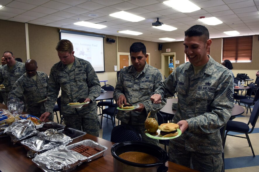U.S. Air Force Airmen fix their plates during the 2017 Air Force Assistance Fund kickoff at Dyess Air Force Base, Texas, March 24, 2017. AFAF project officers grilled burgers and hot dogs for Team Dyess to celebrate the campaign, which aids Airmen and families in their time of need. (U.S. Air Force photo by Senior Airman Kedesha Pennant/Released)
 
