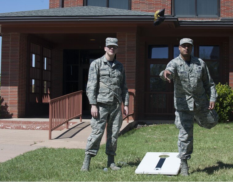 U.S. Air Force Staff Sgt. Trevor A. Taylor-Tillet, contingency support cell NCO in charge, and SrA Daxton Perkins, contracting specialist, both assigned to the 7th Contracting Squadron, compete in a bean bag toss during the 2017 Air Force Assistance Fund kickoff at Dyess Air Force Base, Texas, March 24, 2017. AFAF project officers set up the game for Airmen who attended the event to support the campaign, which uses donations to help Airmen and their families with emergencies, educational assistance and family support. (U.S. Air Force Photo by Amn Kylee Thomas/ Released)

