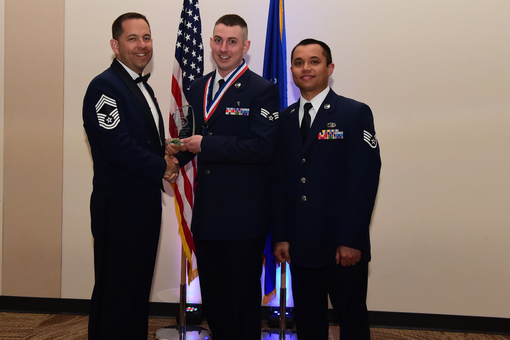 Senior Airman Dane Carder accepts the distinguished graduate award during an Airman Leadership School graduation March 23, 2017, at the Leadership Development Center on Buckley Air Force Base, Colo. This award represents Airmen who stand out as exemplary in academics and leadership among their class. (U.S. Air Force photo by Airman 1st Class Jessica Huggins/Released)