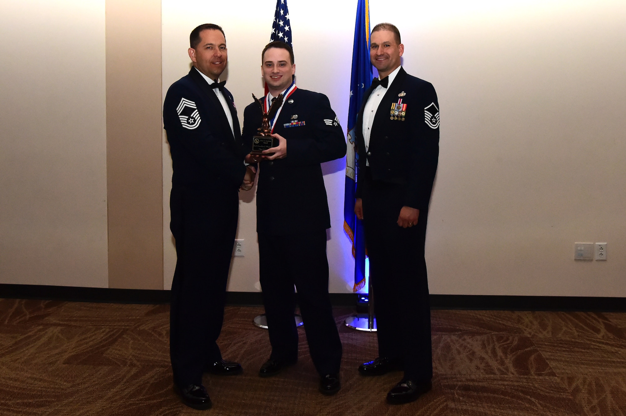 Senior Airman Brandon Moyer accepts the John L. Levitow award during an Airman Leadership School graduation March 23, 2017, at the Leadership Development Center on Buckley Air Force Base, Colo. John L. Levitow is the lowest ranking Airman to earn the Medal of Honor in 1969 during the Vietnam War. (U.S. Air Force photo by Airman 1st Class Jessica Huggins/Released)