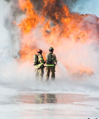 Two airmen from the Mountain Home Air Force Base Fire Department practice extinguishment techniques during a live-fire exercise here, Feb. 16, 2017. Airmen at the Fire Protection Flight train for the worst during their training scenarios. (U.S. Air Force photo by Senior Airman Malissa Lott/Released)