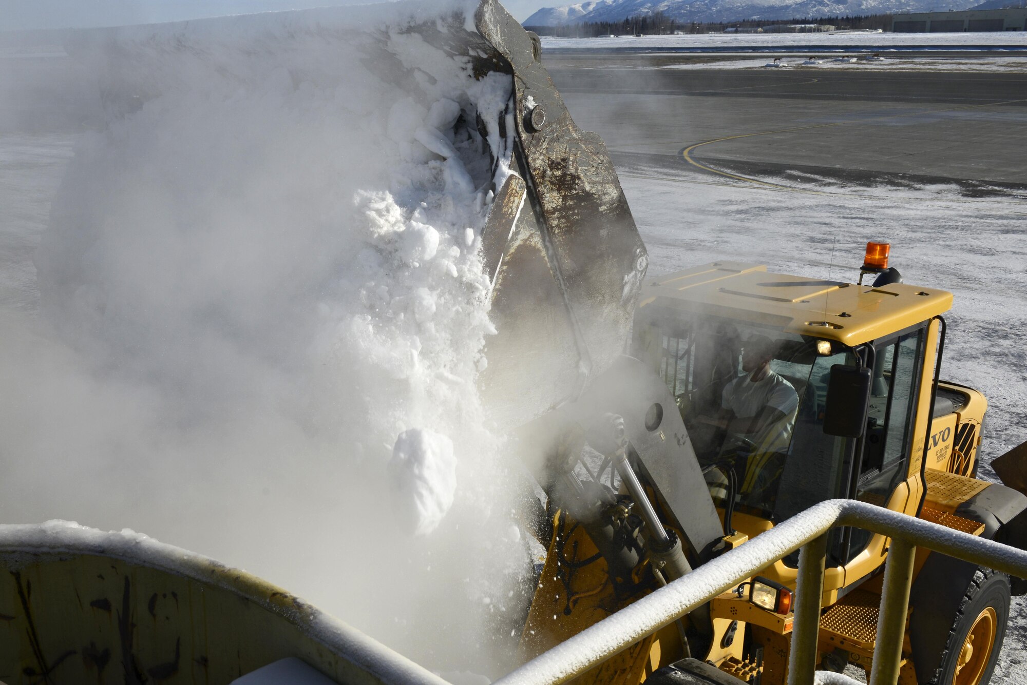 An operator assigned to the 773d Civil Engineering Squadron’s Horizontal Maintenance section, loads ice and snow into a Trecan snowmelter machine on the Joint Base Elmendorf-Richardson flight line, March 22, 2017. This machine, the only one in the U.S. Air Force’s inventory, has been operating for more than 300 hours this winter, allowing crews of two to work 24/7, keeping the flight line operational.
