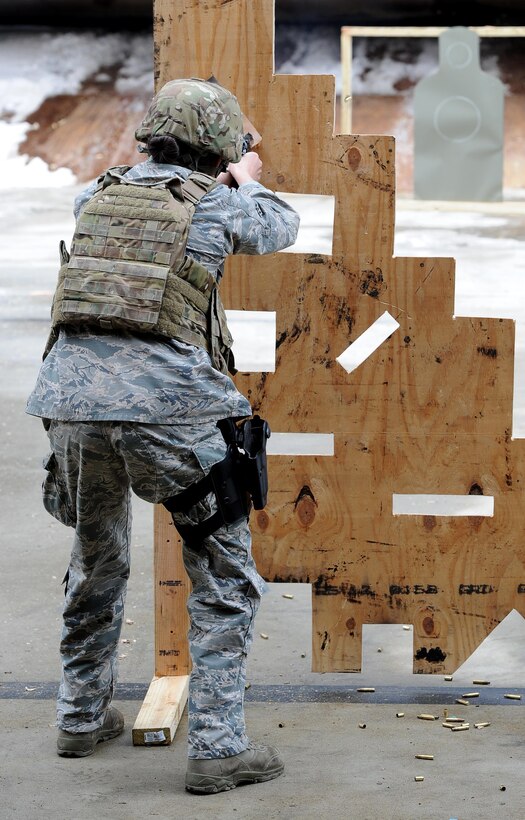 Senior Airman Amanda Gordon, 5th Security Forces Squadron defender, shoots a M9 pistol at a target for Global Strike Challenge tryouts at Minot Air Force Base, N.D., March 16, 2017. The 9 hole board teaches defenders how to shoot in different positions. (U.S. Air Force photo/Senior Airman Kristoffer Kaubisch)
