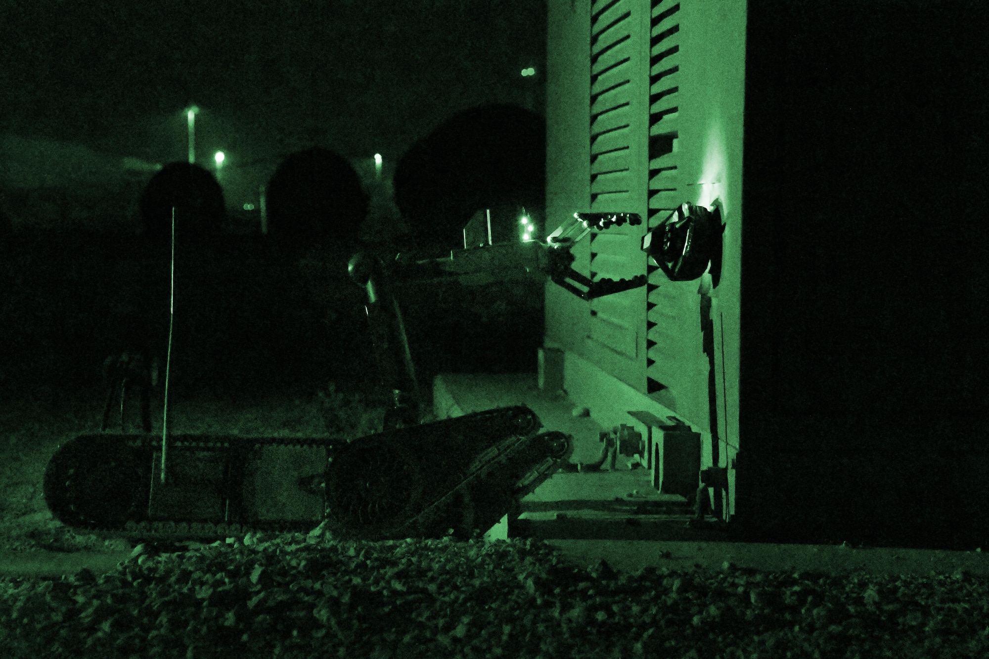 A PACBOT bomb disposal robot removes an improvised explosive device from a transformer during exercise “Vigilant Walrus” at Al Udeid Air Base, Qatar, March 21, 2017. During the exercise, Airmen with the 379th Expeditionary Civil Engineer Squadron Explosive Ordnance Disposal Flight were forced to work at night without the use of white light. (U.S. Air Force photo illustration by Senior Airman Miles Wilson)