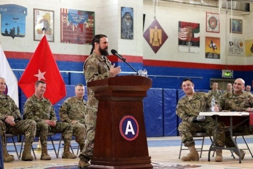 Retired Master Sgt. Chris Corbin, Special Forces senior sergeant, formerly with B company, 3/505th Parachute Infantry Regiment, 7th Special Forces Group, talks to troops in a town hall meeting hosted by Operation Proper Exit, March 14, at Camp Arifjan, Kuwait. Part of Corbin’s healing process is to tell deployed troops how he lost his feet, Feb. 17, 2011, in Afghanistan. These U.S. Army Veterans will have an opportunity to return the area where they were injured and depart on their own terms.