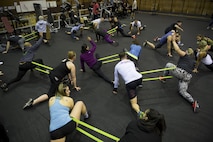 Participants perform warm up stretches during the LifeFit Tour exercise demonstration March 21, 2017, at Yokota Air Base, Japan. The goal of the event was to bring like-minded military members and their families together in a fun learning experience on fundamental exercise safety and form. (U.S. Air Force photo by Airman 1st Class Donald Hudson)