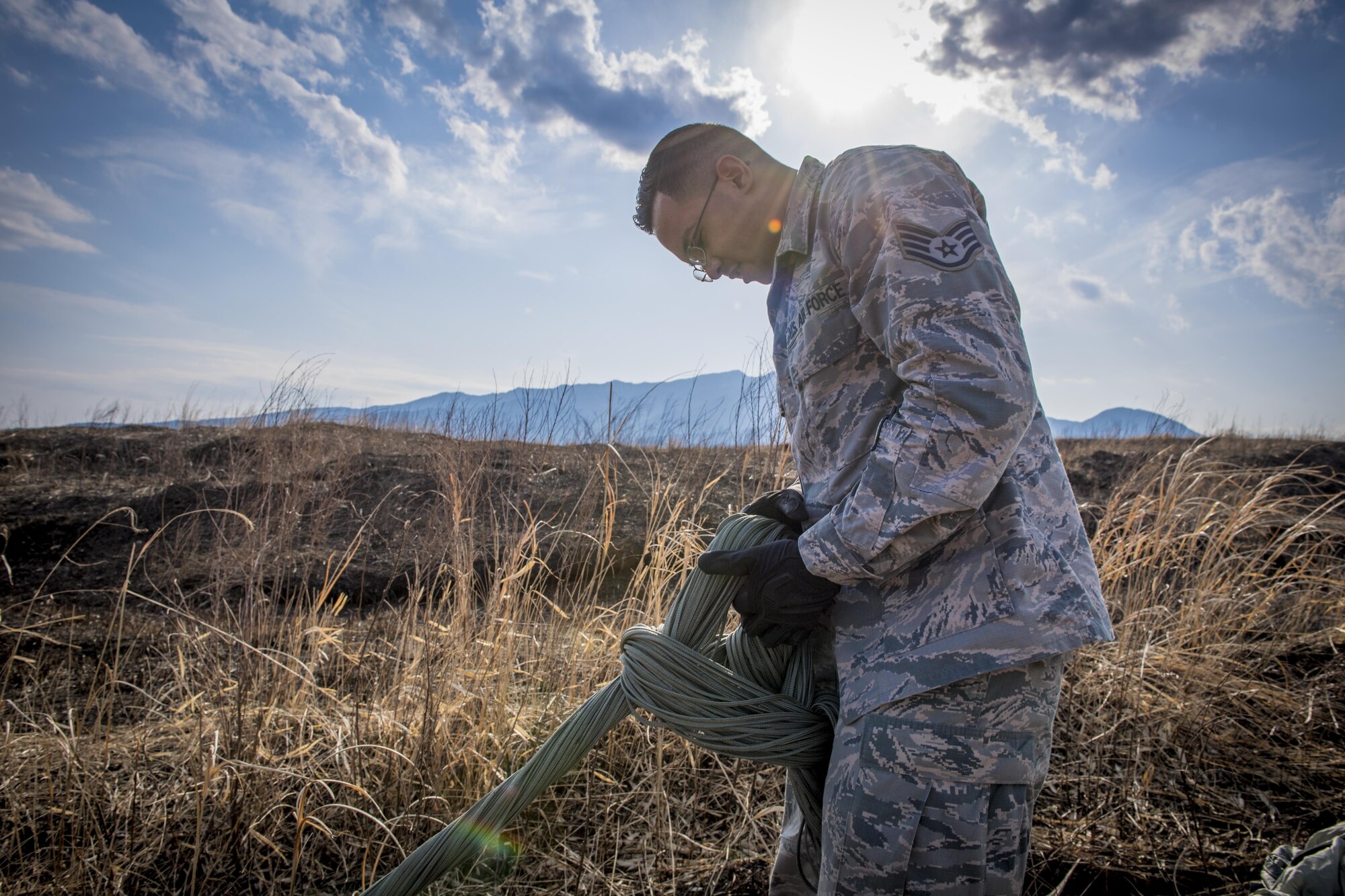Staff Sgt. Marcanthony Khan, 374th Logistics Readiness Squadron air transportation specialist, recovers an equipment parachute during a cargo drop training exercise March 22, 2017, at Camp Fuji, Japan. From packing the parachutes to recovering them after the drop exercises are complete, the 374 LRS is responsible for every step in building the cargo pallets to ensuring the supplies land safely on the ground. (U.S. Air Force photo by Airman 1st Class Donald Hudson)