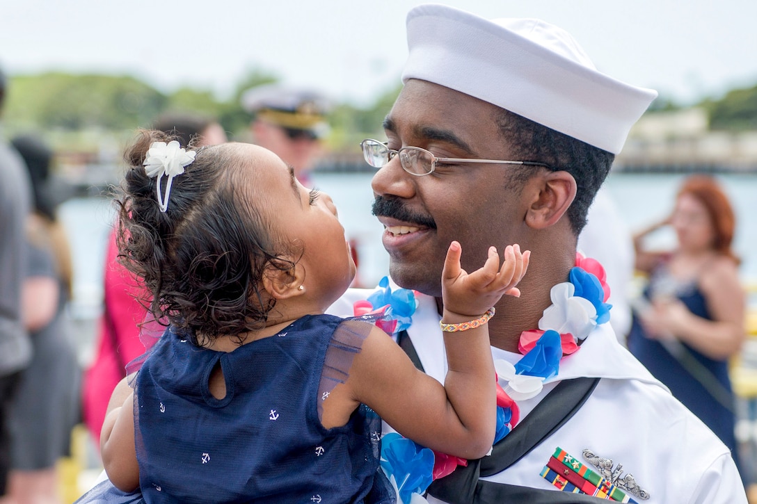 Navy Petty Officer 2nd Class Bryce Mack hugs his daughter upon returning from six-month deployment to the western Pacific at Joint Base Pearl Harbor-Hickam, Hawaii, March 23, 2017. Navy photo by Petty Officer 2nd Class Michael H. Lee