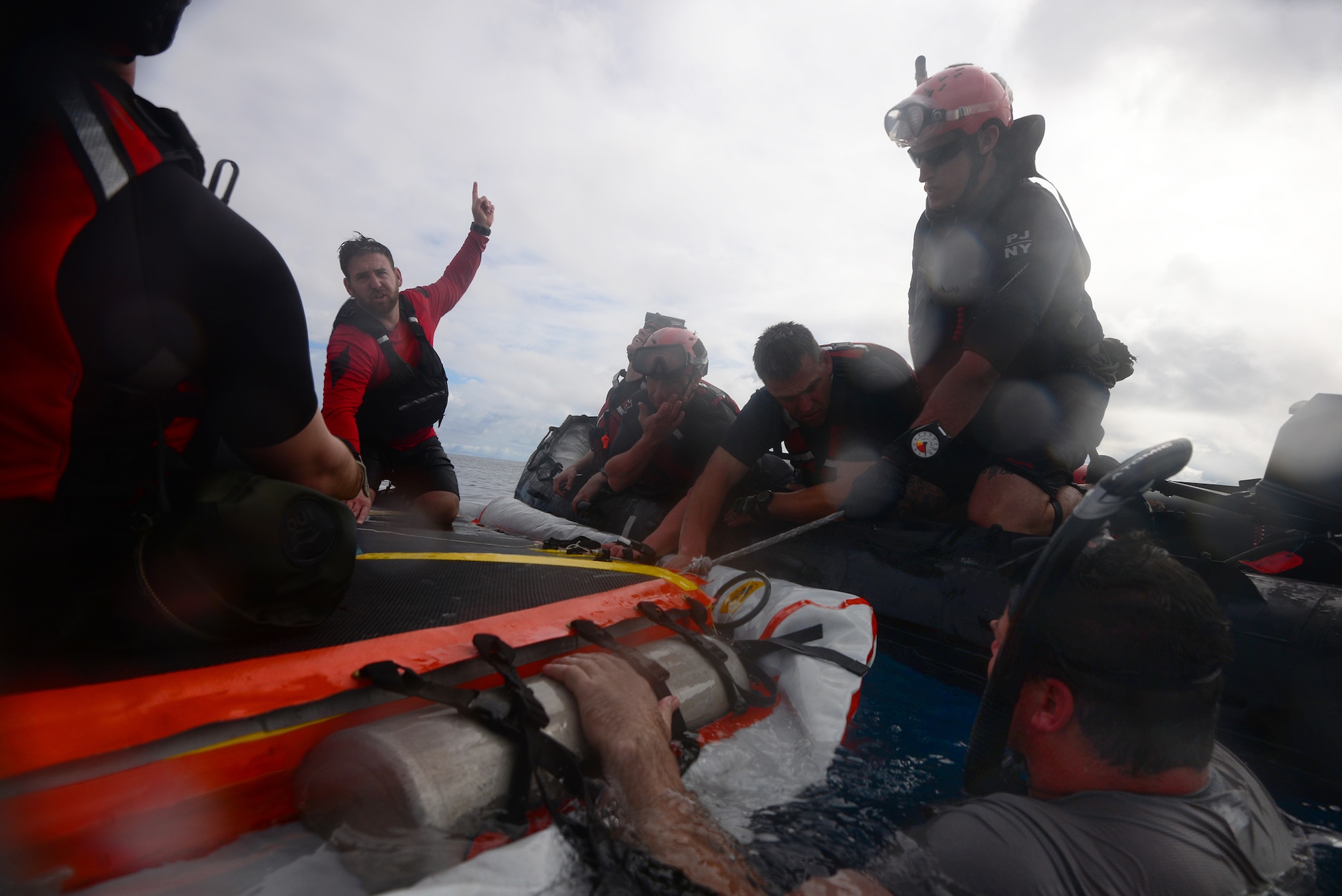 Brandon Daugherty, a Space Medical Contingency Specialist with the 45th Operations Group, Detachment 3, Human Spaceflight Support, talks to the team on the "Front Porch" floatation device that was unfolded and inflated by Pararescuemen and Combat Rescue Officers from the 103rd Rescue Squadron following a jump from the back of a C-17 at Marine Corps Base Hawaii, March 5, 2017. During this training, a rigid inflatible boat (known as a "Hard Duck") was dropped from a C-17 along with several jumpers and an inflatable device known as the "Front Porch".This device is intended to be mated to the Orion spacecraft, and can be used to support astronauts who have made a water landing in the Orion spacecraft following a flight. (U.S. Air National Guard Photo by Staff Sgt. Christopher S. Muncy)