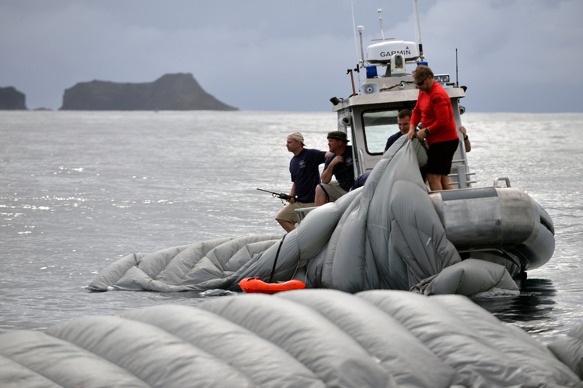 Pararescuemen and Combat Rescue Officers from the 103rd Rescue Squadron load onto their boat after being dropped from the back of a C-17 Globemaster during a joint training exercise with Human Space Flight Support (45th Operations Group, Detachment 3) at Marine Core Base Hawaii, March 5, 2017.During this training, a rigid inflatible boat (known as a "Hard Duck") was dropped from a C-17 along with several jumpers and an inflatable device known as the "Front Porch".This device is intended to be mated to the Orion spacecraft, and can be used to support astronauts who have made a water landing in the Orion spacecraft following a flight. (U.S. Air National Guard Photo by Staff Sgt. Christopher S. Muncy)