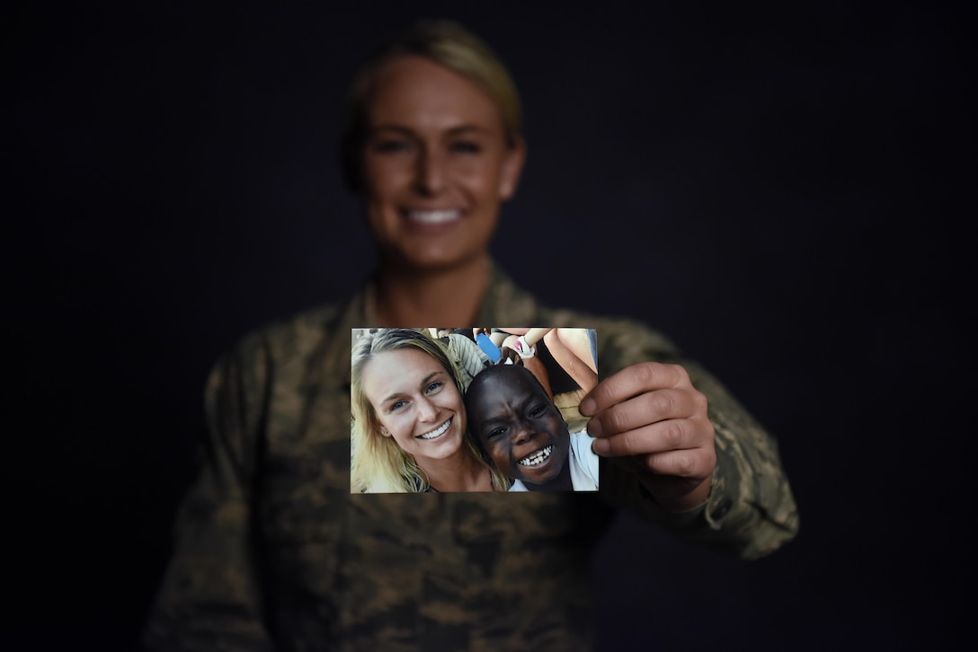 Air Force Senior Airman Courtney Iannucci, an intelligence specialist assigned to the Ohio Air National Guard’s 180th Fighter Wing, holds a photo up from her volunteer mission to Ghana to care for orphans at the wing’s headquarters in Swanton, Ohio, March 12, 2017. Ohio Air National Guard photo by Airman Hope Geiger