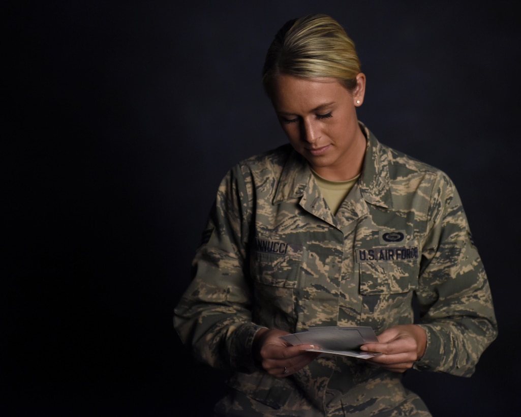 Air Force Senior Airman Courtney Iannucci, an intelligence specialist assigned to the Ohio Air National Guard’s 180th Fighter Wing, looks through photos from her three-week volunteer trip to Ghana to care for orphans at the wing’s headquarters in Swanton, Ohio, March 12, 2017. Ohio Air National Guard photo by Airman Hope Geiger