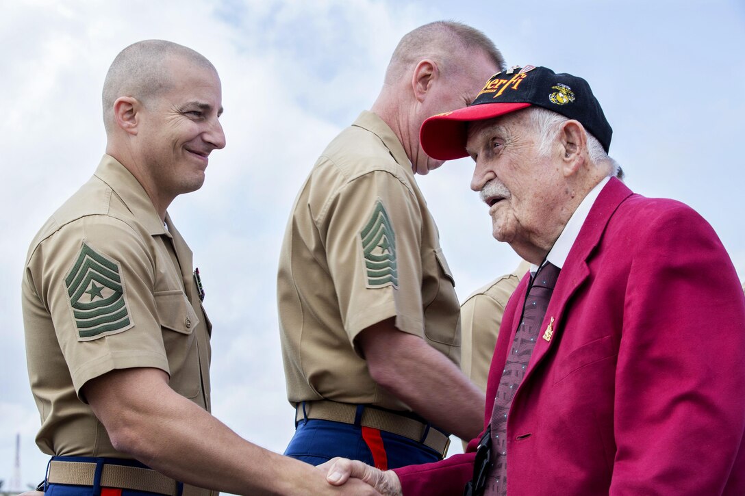 Iwo Jima veteran George Cattalona, right, is greeted by senior Marine Corps noncommissioned officers after landing on the flightline of Iwo To, Japan, March 25, 2017, for the 72nd anniversary of the Battle of Iwo Jima at the Reunion of Honor memorial. Marine Corps photo by Lance Cpl. Brooke Deiters