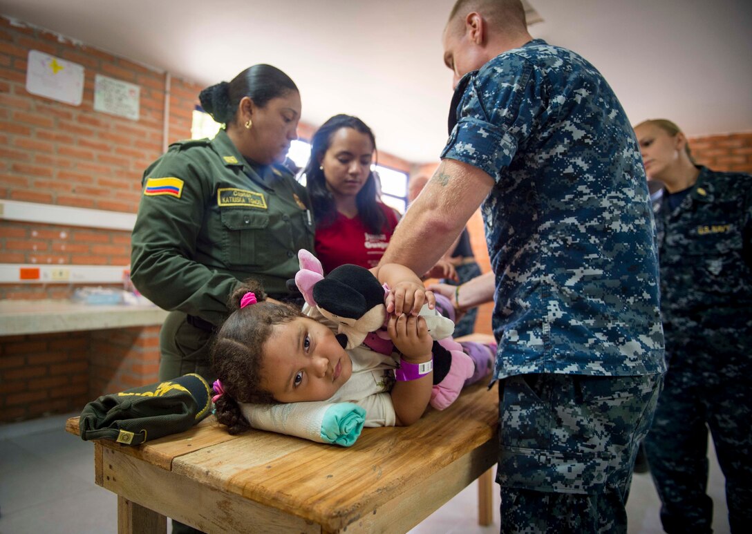 MAYAPO, Colombia (March 25, 2017) - Hospital Corpsman 2nd Class Joshua Crisano, a native of Williamsburg, Va., assigned to Naval Hospital Jacksonville, Fla., teaches physical therapy stretches to the mother of a host nation child at the Continuing Promise 2017 (CP-17) medical site in Mayapo, Colombia. CP-17 is a U.S. Southern Command-sponsored and U.S. Naval Forces Southern Command/U.S. 4th Fleet-conducted deployment to conduct civil-military operations including humanitarian assistance, training engagements, and medical, dental, and veterinary support in an effort to show U.S. support and commitment to Central and South America. (U.S. Navy photo by Mass Communication Specialist 2nd Class Shamira Purifoy)