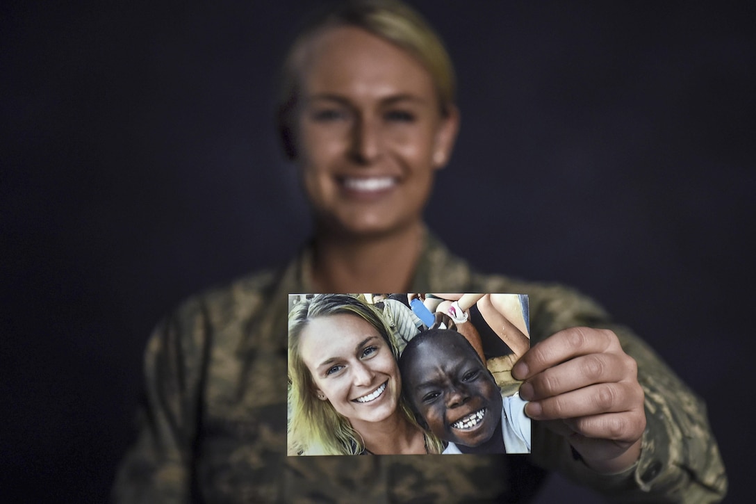 Air Force Senior Airman Courtney Iannucci, an intelligence specialist assigned to the Ohio Air National Guard’s 180th Fighter Wing, holds a photo at the wing’s headquarters in Swanton, Ohio, March 12, 2017, from her volunteer mission to Ghana to care for orphans. Ohio Air National Guard photo by Airman Hope Geiger