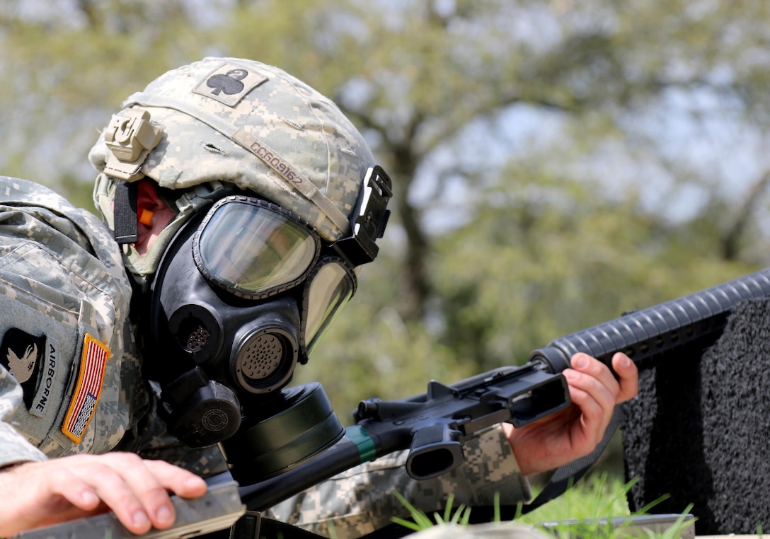 Army Reserve Spc. Enrique Gonzalez, an Elkton, Maryland native and infrantryman with Echo Company, 1-304th Infantry Regiment, 4th Brigade, 98th Training Division (Initial Entry Training) loads his M16 rifle while wearing his protective mask during the 108th Training Command (IET) Best Warrior Competition at Camp Bullis, Texas, March 19-24, 2017.  (U.S. Army Reserve photo by Maj. Michelle Lunato.)