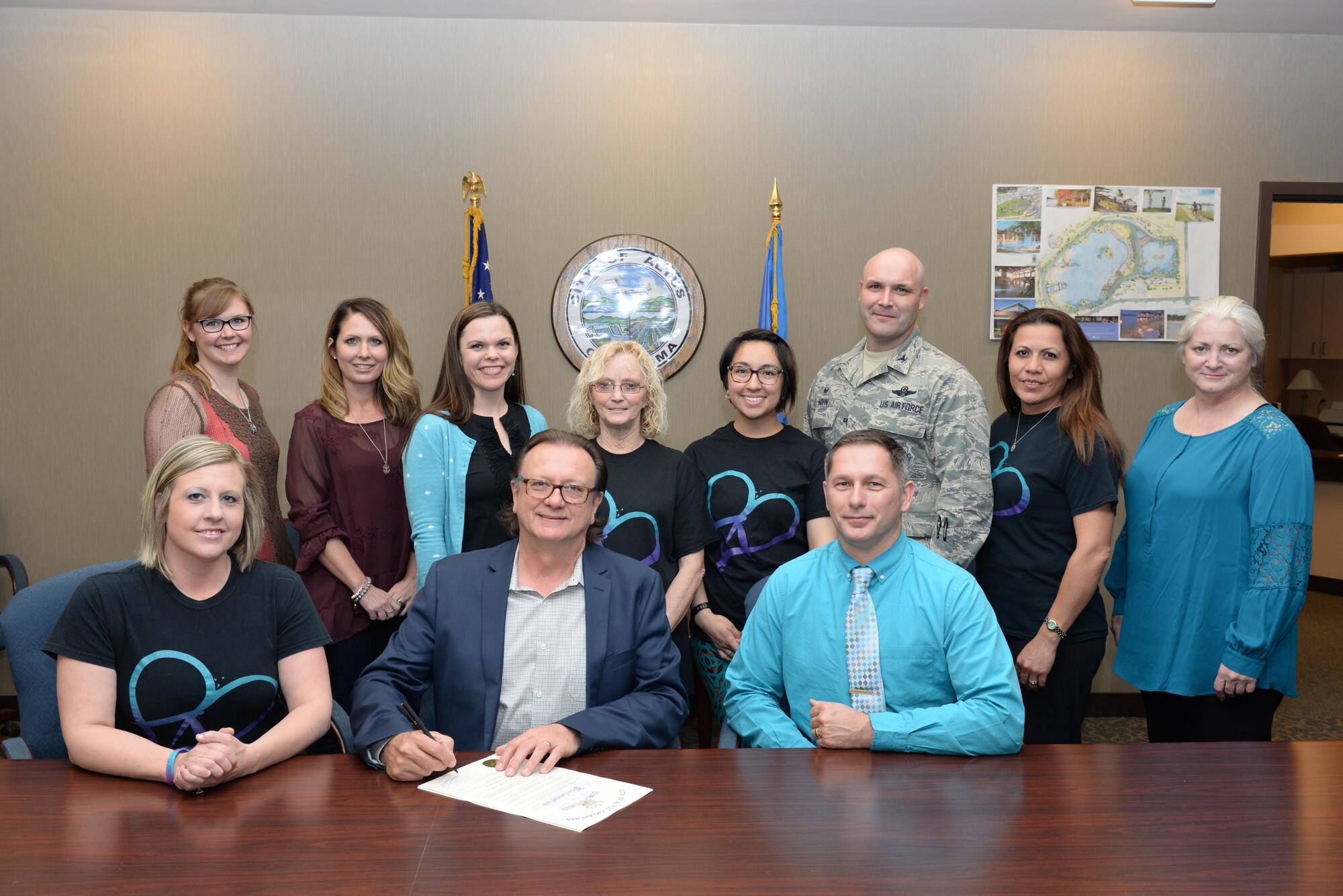 Jack Smiley, mayor of the City of Altus, Matt O'Dell, 97th Wing Staff Agencies sexual assault response coordinator, and U.S. Air Force Col. Todd Hohn, 97th Air Mobility Wing commander, pose with Altus community members, March 21, 2017, Altus, Oklahoma. The City of Altus and Altus Air Force Base came together to sign a proclamation, reaffirming the support to sexual assault victims as part of Sexual Assault Awareness and Prevention Month.