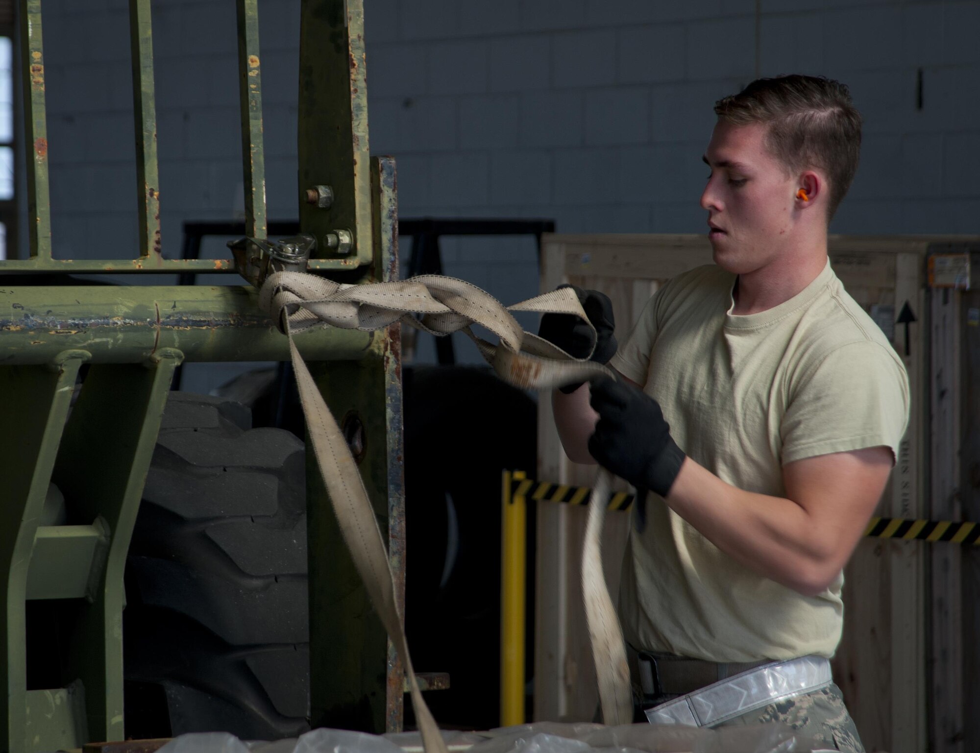 Senior Airman Landon Adams, a vehicle operator with the 6th Logistics Readiness Squadron, ties a daisy-chain knot before transferring a pallet to the cargo deployment function yard during an exercise at MacDill Air Force Base, Fla., March 21, 2017. The daisy-chain knot is used to secure the access strap for safety. (U.S. Air Force photo by Airman 1st Class Mariette Adams)
