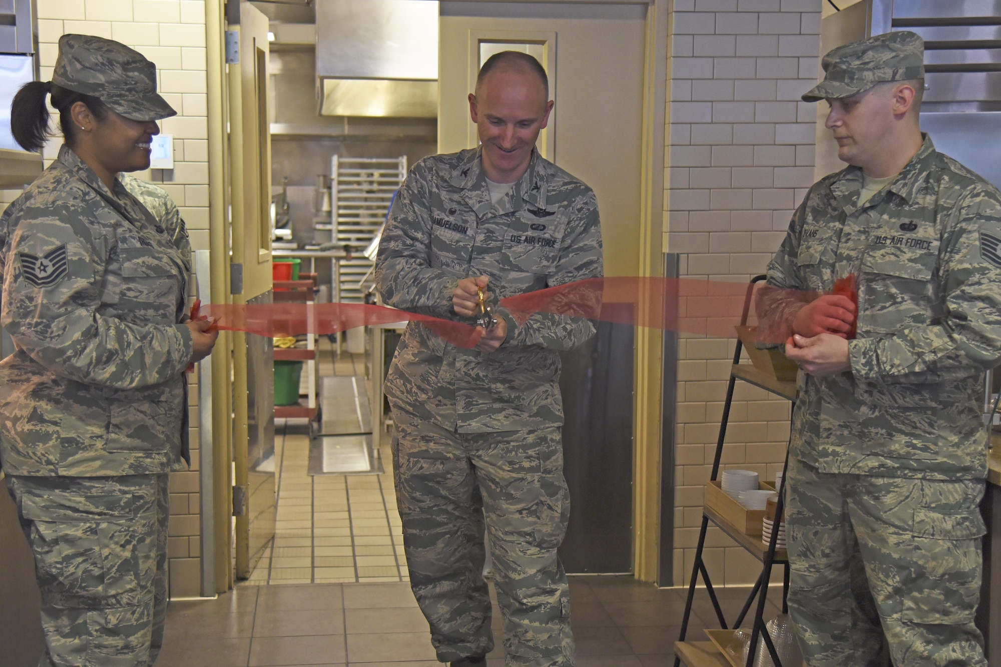 Col. Ryan Samuelson, 92nd Air Refueling Wing commander, cuts the ribbon during the Warrior Mission Essential Feeding Facility new concept launch Mar. 27, 2017, at Fairchild Air Force Base, Washington. The new concepts are an expansion on the standard Food Transformation Initiative operation, making Fairchild the third base in the Air Force to incorporate the healthier and cost saving Super Sonic Subs, CIAO Pizza and Big City Grill. (U.S. Air Force photo/Senior Airman Mackenzie Richardson)