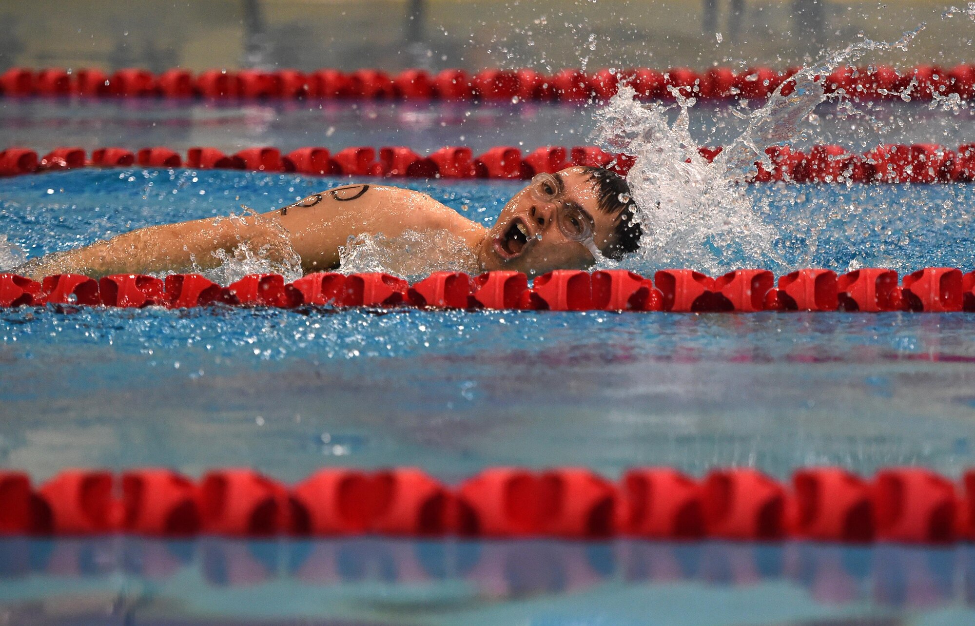 A Dimond High School swimmer swims laps at the Buckner Physical Fitness Center pool during the JROTC Indoor Triathlon at Joint Base Elmendorf-Richardson, Alaska, March 25, 2017. Nine teams of eight athletes competed in a timed swim, bike and run. The annual event has been hosted at Buckner PFC since January 2005.