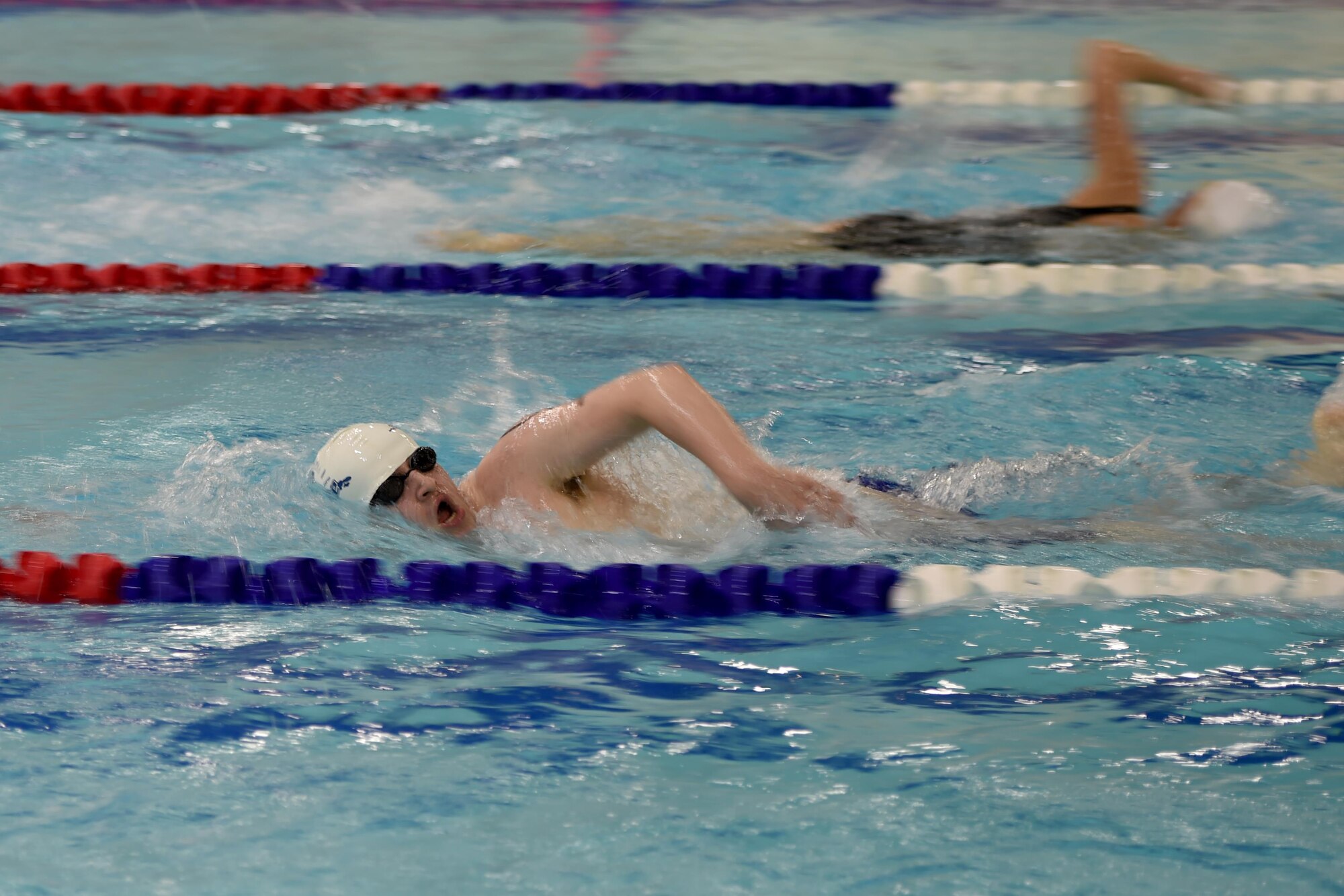 Chugiak High School swimmers swim laps at the Buckner Physical Fitness Center pool during the Junior ROTC Indoor Triathlon at Joint Base Elmendorf-Richardson, Alaska, March 25, 2017. Nine teams of eight athletes competed in a timed swim, bike and run. The annual event has been hosted at Buckner PFC since January 2005. 