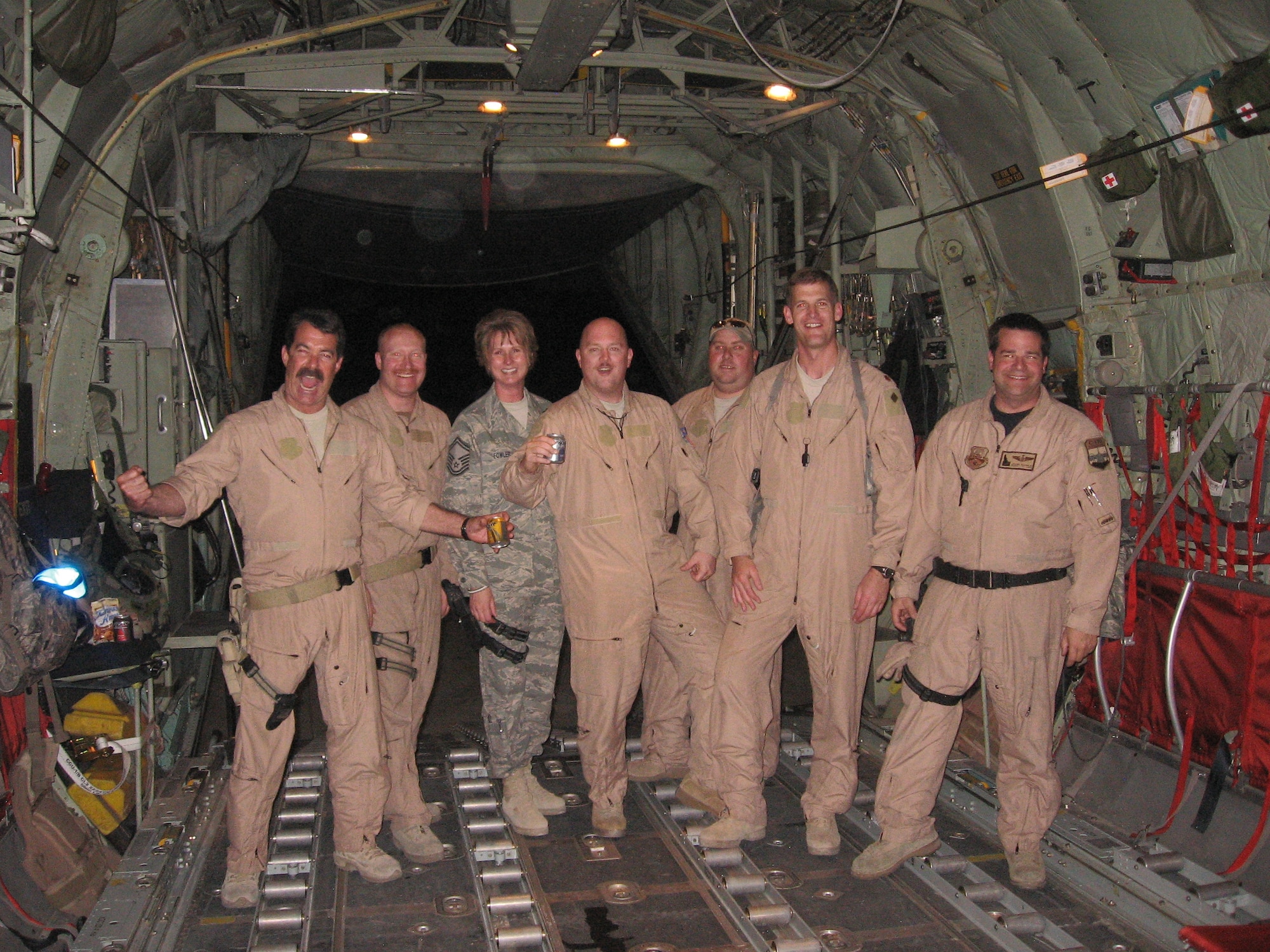 Chief Master Sgt. Milissa Fowler, (third from the left) 153rd Airlift Wing, Force Support Squadron superintendent, poses in the back of a C-130H during her support of Operation Enduring Freedom in 2009 where she assisted with protocol. (Courtesy photo)