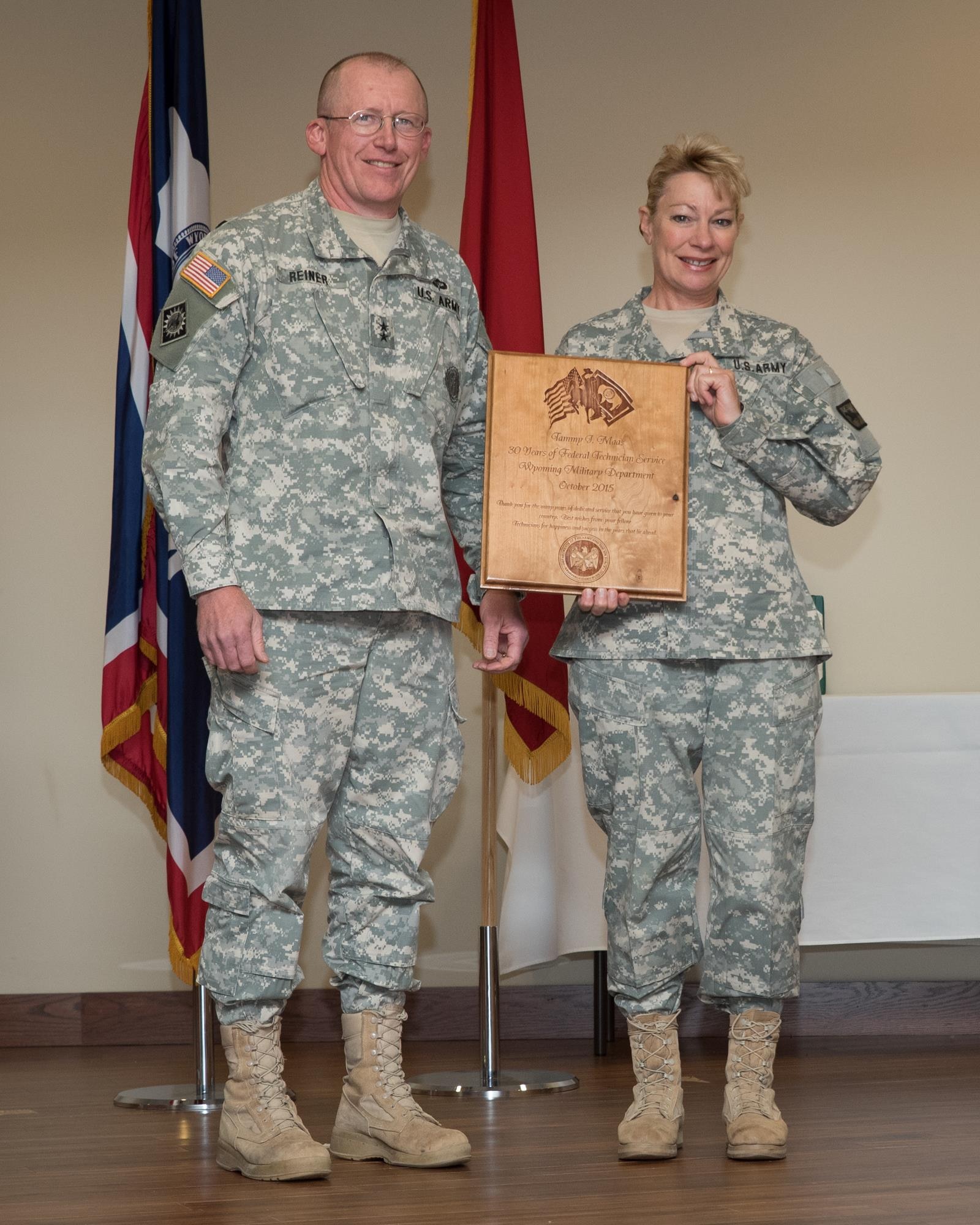 Maj. Gen. Luke Reiner, Wyoming adjutant general, and Brig. Gen. Tammy Maas, assistant adjutant general-Army, celebrate Maas' 30 years of federal technician service at a celebration at the Joint Force Readiness Center, Cheyenne, Wyoming, August 2015. (Photo by Master Sgt. Charles Delano)