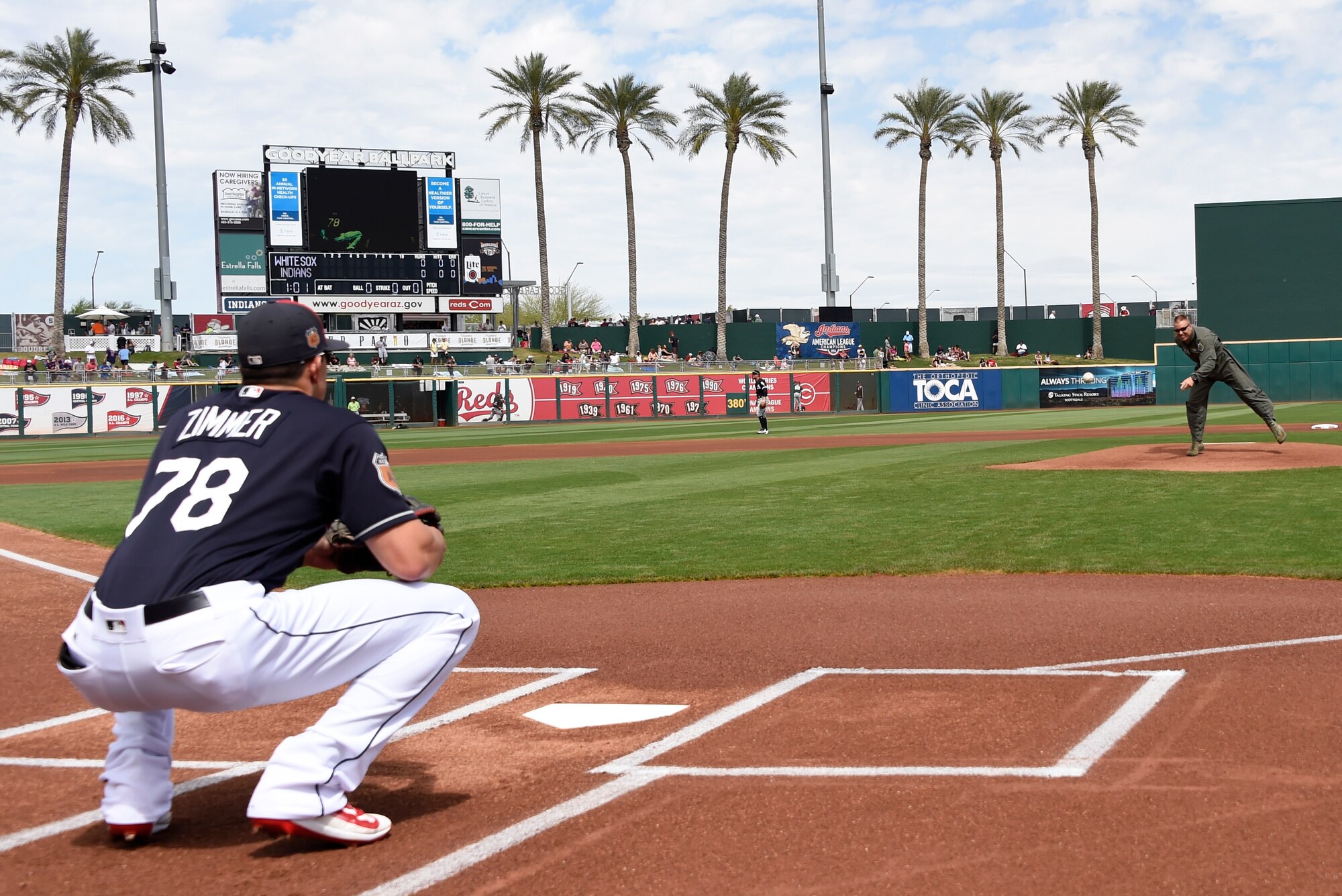 Brig. Gen. Brook Leonard, 56th Fighter Wing commander, throws the first pitch of the game between the Chicago White Sox and the Cleveland Indians to Bradley Zimmer, Cleveland Indians center fielder, March 25, 2017, at Goodyear Ballpark in Goodyear, Ariz. Leonard threw the first pitch as part of the celebration to mark the Great American Defense Community Award being awarded to the West Valley Partners. (U.S. Air Force photo by Airman 1st Class Alexander Cook)