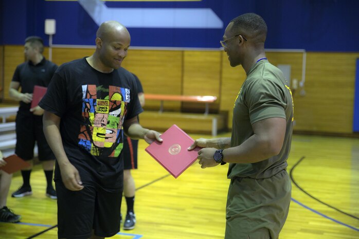 U.S Marine Corps Staff Sgt. Charles London, Marine Corps Air Station Iwakuni, Japan’s first official Force Fitness Instructor, gives U.S. Marine Corps Cpl. Wesley Thompson, a supply administration specialist with Marine Air Group (MAG) 12, a certificate for completing an eight-week physical training course, March 17, 2017. Wesley was part of the first group of Marines to go through the course at MCAS Iwakuni. The recently implemented Force Fitness Instructors are capable of designing individual and unit-level holistic fitness programs, and they serve as subject matter experts on physical fitness and sports-related injury prevention.
