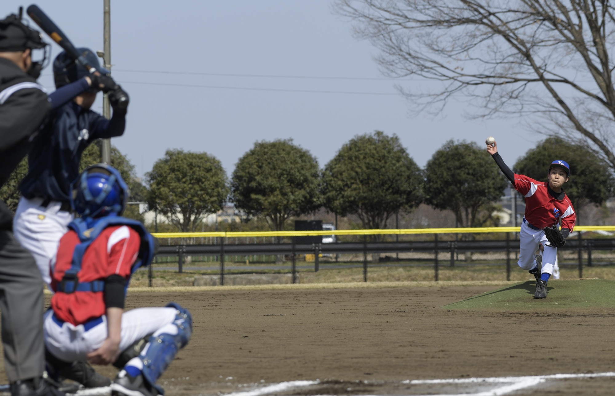 A pitcher from the Yokota Samurai baseball team throws the first pitch during the Inaugural Japan-US Friendship Youth Baseball Game at Yokota Air Base, Japan, March 25, 2017. The Yokota Samurai Baseball team consists of 23 players from Yokota’s middle and high schools. (U.S. Air Force photo by Staff Sgt. David Owsianka)