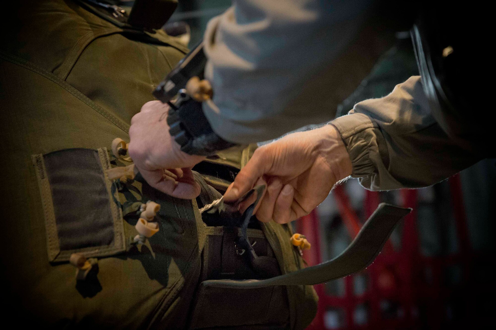 A U.S. marine with the 3rd Reconnaissance Battalion, 3rd Marine Division, 3rd Marine Expeditionary Force fastens and checks a parachute before jump training on Yokota Air Base, Japan, March 23, 2017. The training not only allowed the Marines to practice jumping, but it also allowed the Yokota aircrews to practice flight tactics and timed-package drops. (U.S. Air Force photo by Yasuo Osakabe)