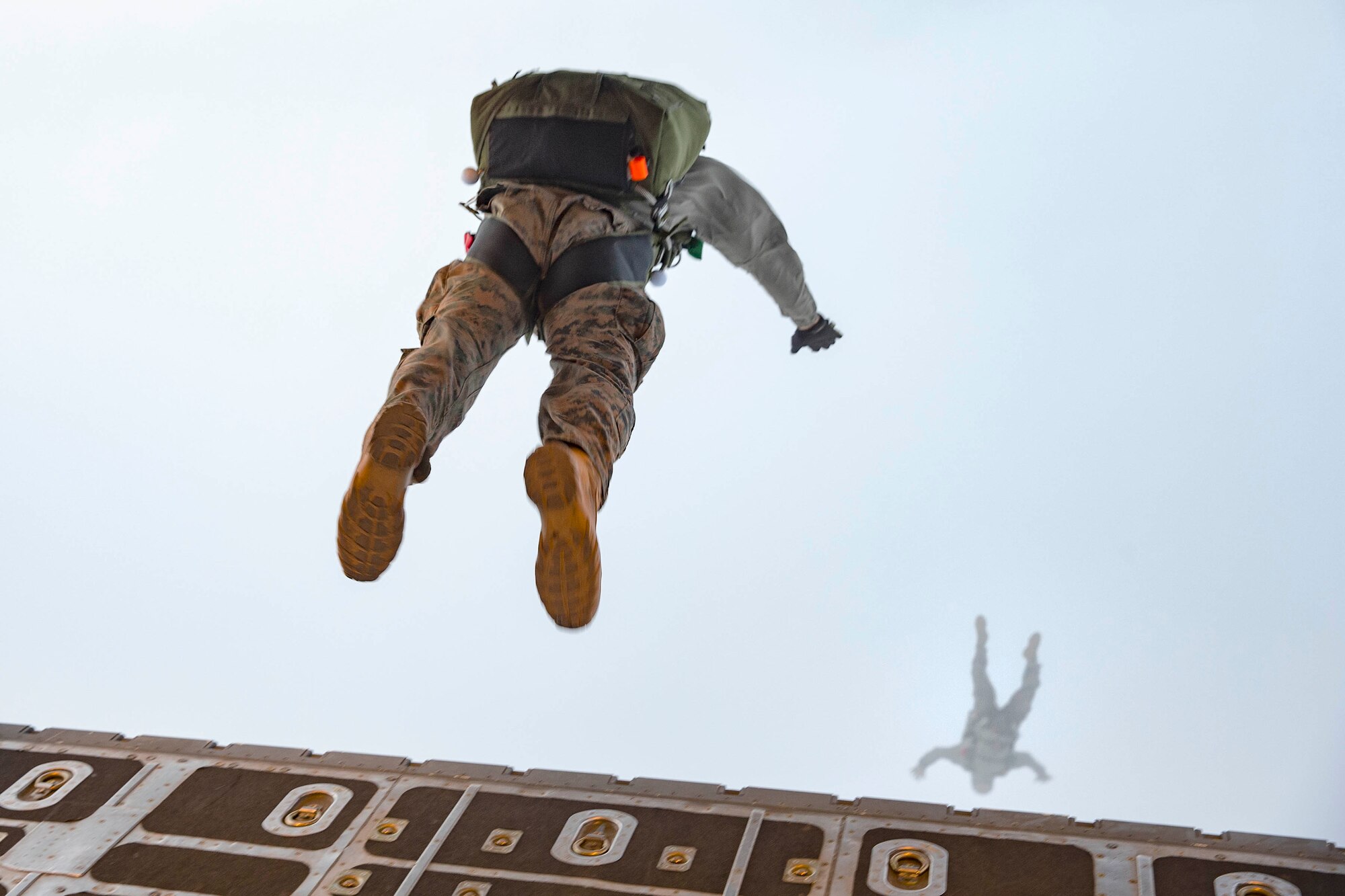 U.S. Marines jump out of the back of an Air Force C-130H Hercules at approximately 10,000 feet over Yokota Air Base, Japan, March 23, 2017, during jump week. The training not only allowed the Marines to practice jumping, but it also allowed the Yokota aircrews to practice flight tactics and timed-package drops day and night. (U.S. Air Force photo by Yasuo Osakabe)