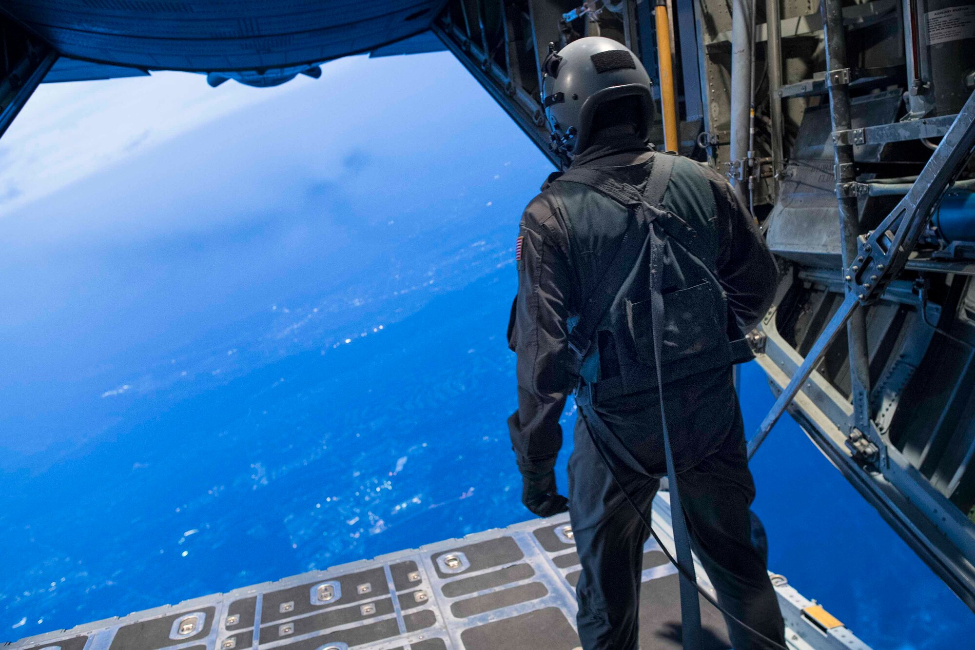 An Air Force loadmaster with the 36th Airlift Squadron observes the last few Marines jumpers from a C-130H Hercules over Yokota Air Base, Japan, March 23, 2017, during jump week. The training not only allowed the Marines to practice jumping, but it also allowed the Yokota aircrews to practice flight tactics and timed-package drops day and night. (U.S. Air Force photo by Yasuo Osakabe)