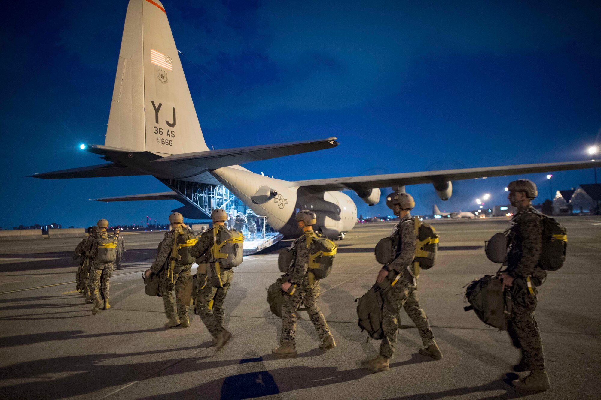U.S. Marines, assigned to the 3rd Reconnaissance Battalion, 3rd Marine Division, 3rd Marine Expeditionary Force, board an Air Force C-130H Hercules during jump week at Yokota Air Base, Japan, March 23, 2017. The training not only allowed the Marines to practice jumping, but it also allowed the Yokota aircrews to practice flight tactics and timed-package drops. (U.S. Air Force photo by Yasuo Osakabe)
