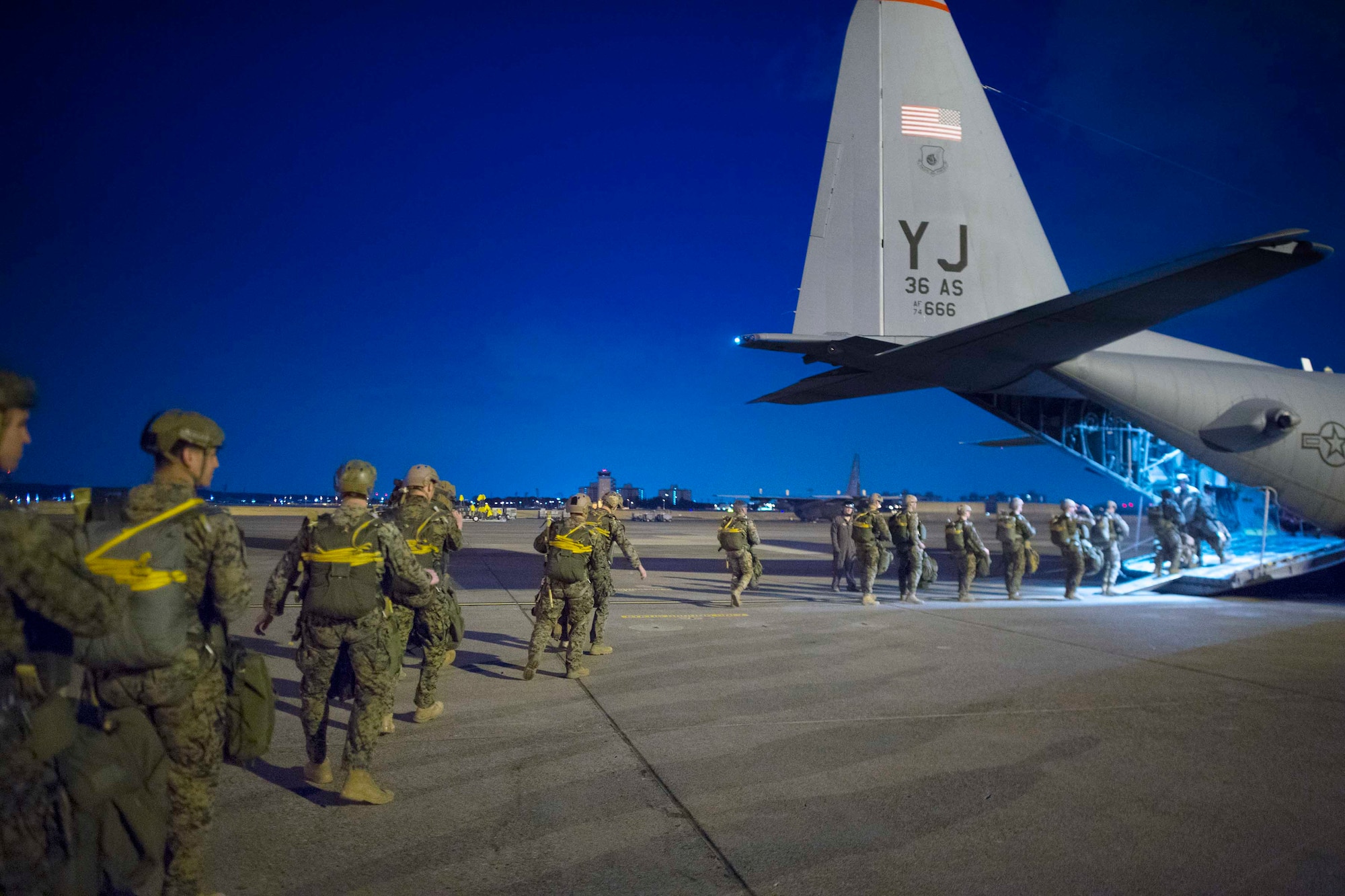 U.S. Marines, assigned to the 3rd Reconnaissance Battalion, 3rd Marine Division, 3rd Marine Expeditionary Force, board an Air Force C-130H Hercules during jump week at Yokota Air Base, Japan, March 23, 2017. The training not only allowed the Marines to practice jumping, but it also allowed the Yokota aircrews to practice flight tactics and timed-package drops. (U.S. Air Force photo by Yasuo Osakabe)