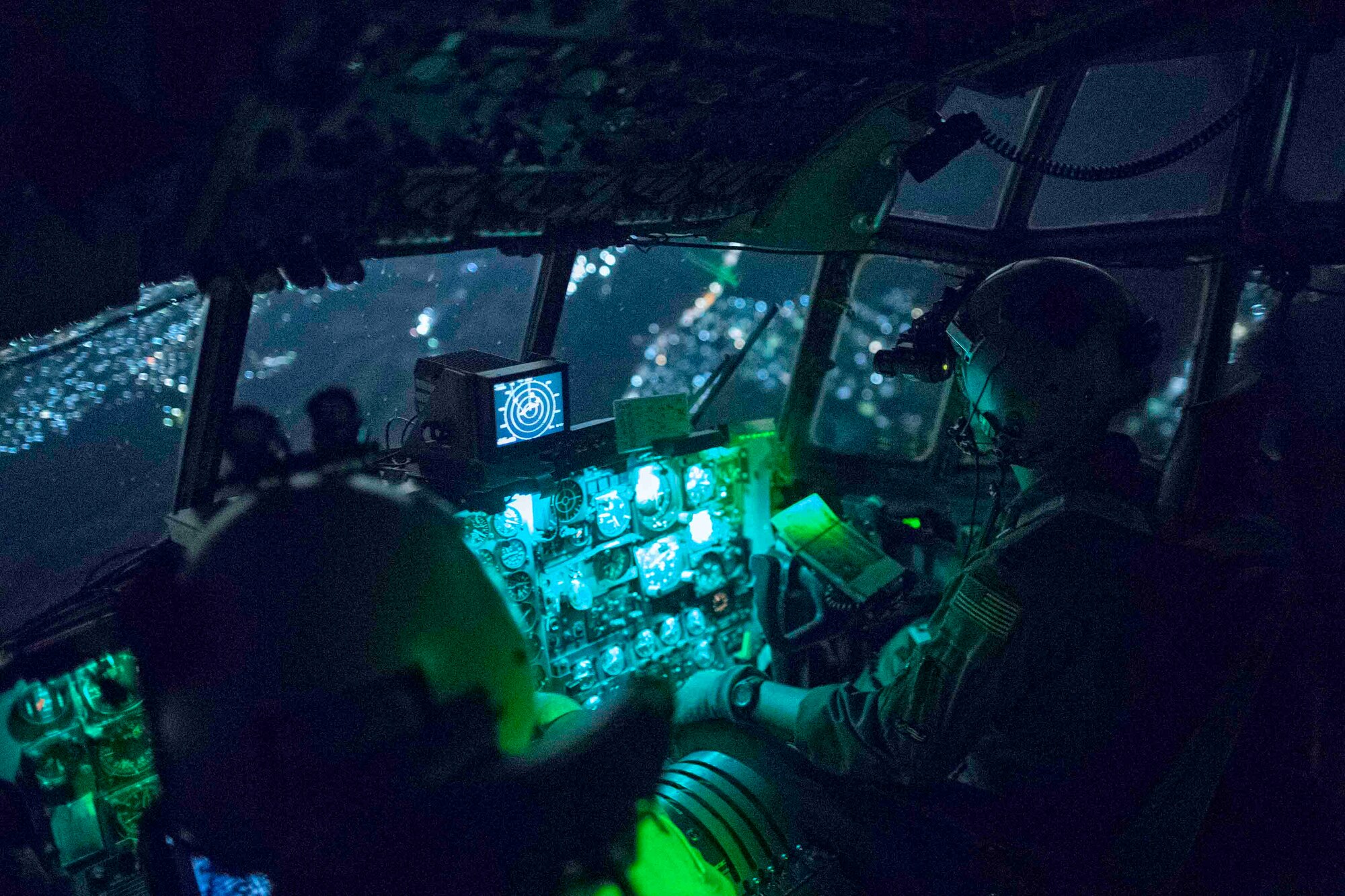 (Right to left) Capt. Travis Wilkes, 374th Operations Group C-130 flight commander, and Capt. Jeremy Sarro, 36th Airlift Squadron C-130 pilot, wear night vision goggles during jump week over Yokota Air Base, Japan, March 23, 2017. The training not only allowed the Marines to practice jumping, but it also allowed the Yokota aircrews to practice flight tactics and timed-package drops. (U.S. Air Force photo by Yasuo Osakabe)