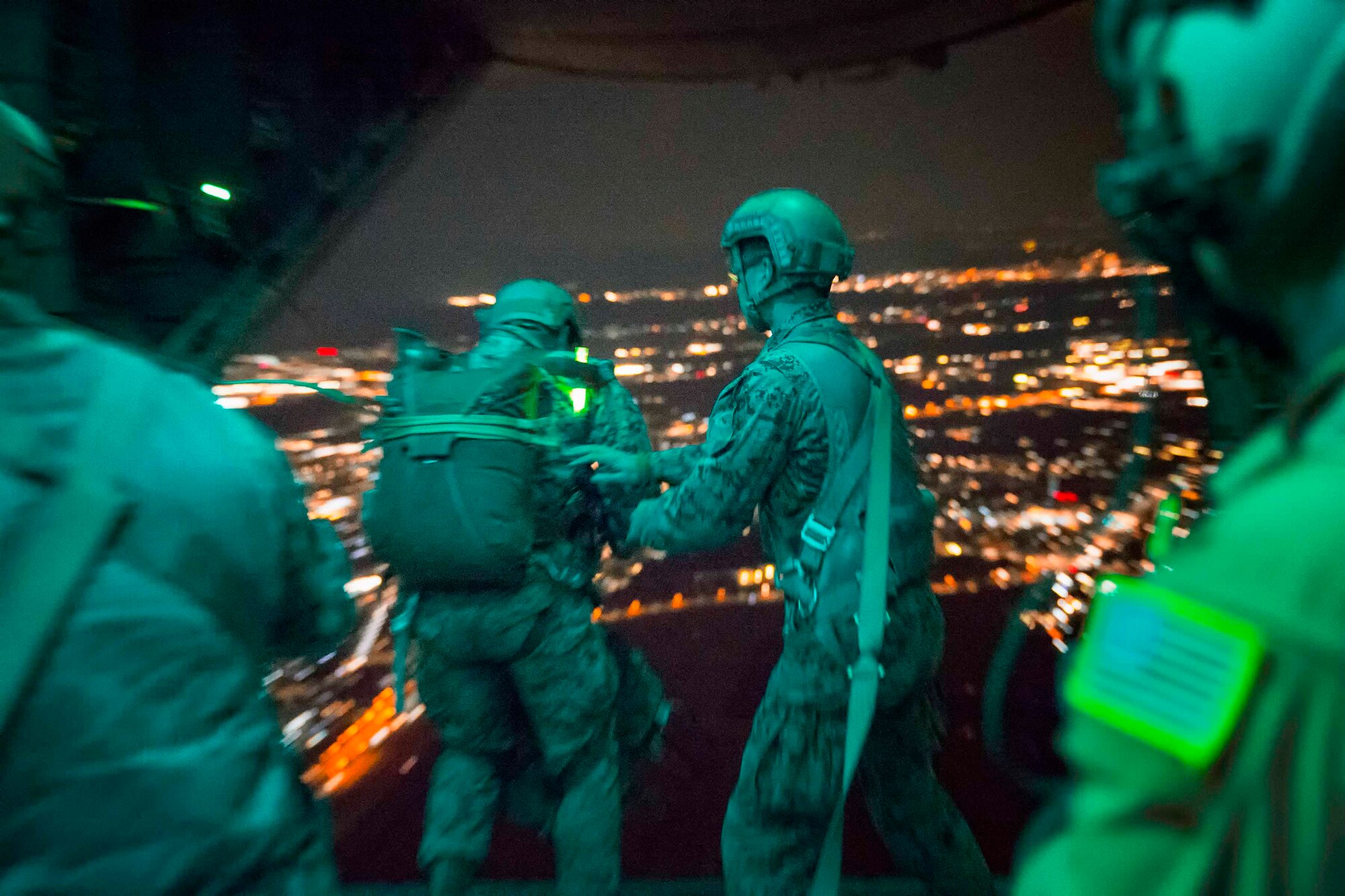 A U.S. Marine jumps from the back of an Air Force C-130H Hercules aircraft during jump week at Yokota Air Base, Japan, March 23, 2017. The training not only allowed the Marines to practice jumping, but it also allowed the Yokota aircrews to practice flight tactics and timed-package drops day and night. (U.S. Air Force photo by Yasuo Osakabe)