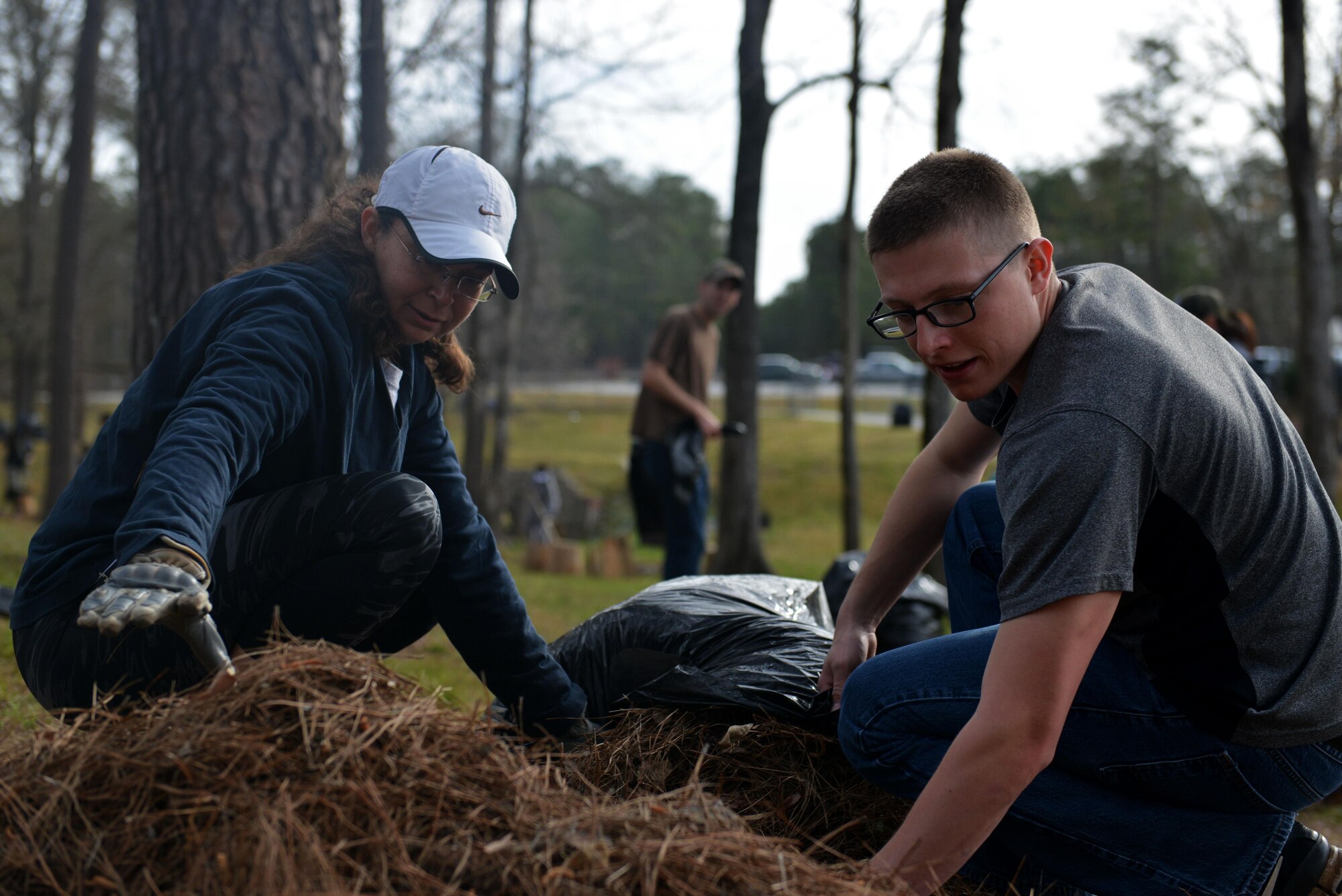 U.S. Air Force Senior Master Sgt. Christina Tinsley, 20th Force Support Squadron (FSS) superintendent, left, and 2nd Lt. Steven Prentice, 20th FSS food services officer, right, scoop debris into a bag during the ninth annual Beautify Wateree event at Wateree Recreation Area near Camden, S.C., March 25, 2017. In around three hours, volunteers removed approximately 2,500 pounds of debris from the area, allowing Wateree staff to focus on taking care of the cabins. (U.S. Air Force photo by Airman 1st Class Destinee Sweeney)