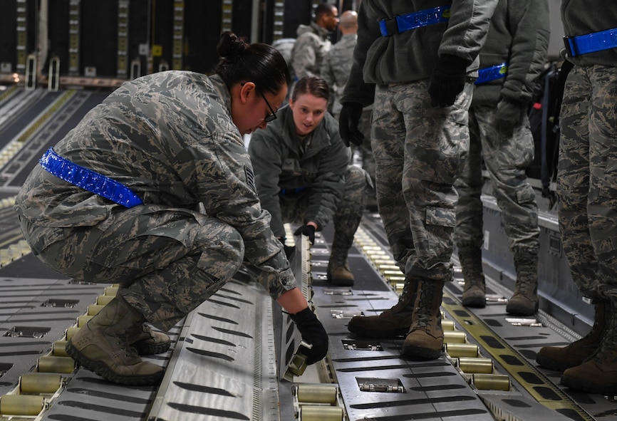 Staff Sgt. Jacquelyn Alvarez, 721st Aerial Port Squadron NCO in charge of the Unit Learning Center, helps a student flip rollers over inside a C-17 Globemaster III before loading cargo onto the aircraft on Ramstein Air Base, Germany, March 21, 2017. The Unit Learning Center provides new Airmen the training required for them to complete their upgrade training for passenger services, air freight, and ramp services. (U.S. Air Force photo by Senior Airman Tryphena Mayhugh)