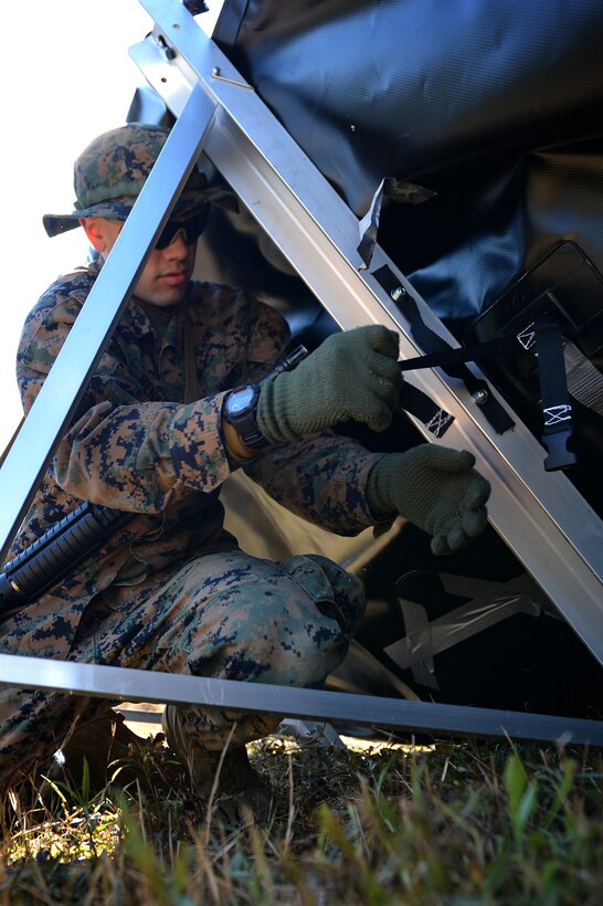 U.S. Marine Corps Pfc. Daniel Henkel, Marine Wing Support Detachment 31 bulk fuel specialist, stationed at Marine Corps Air Station Beaufort, S.C., fastens a restraint on an all-terrain berm at Poinsett Electronic Combat Range near Wedgefield, S.C., March 23, 2017. Defense Department militaries utilize berms as a transportable fuel-holding facility, capable of catching possible fuel leaks in a deployed environment. (U.S. Air Force photo by Airman 1st Class Christopher Maldonado)