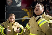 U.S. Air Force Chief Master Sgt. Jennifer Brembah, 52nd Mission Support Group chief enlisted manager, poses while Col. Steven Zubowicz, 52nd MSG commander, cools off after a live fire exercise at Spangdahlem Air Base, Germany, March 23, 2017. MSG leaders were invited to participate in the controlled fire training, which provided Saber firefighters practice in hose advancement and extinguishing techniques. (U.S. Air Force photo by Airman 1st Class Preston Cherry)